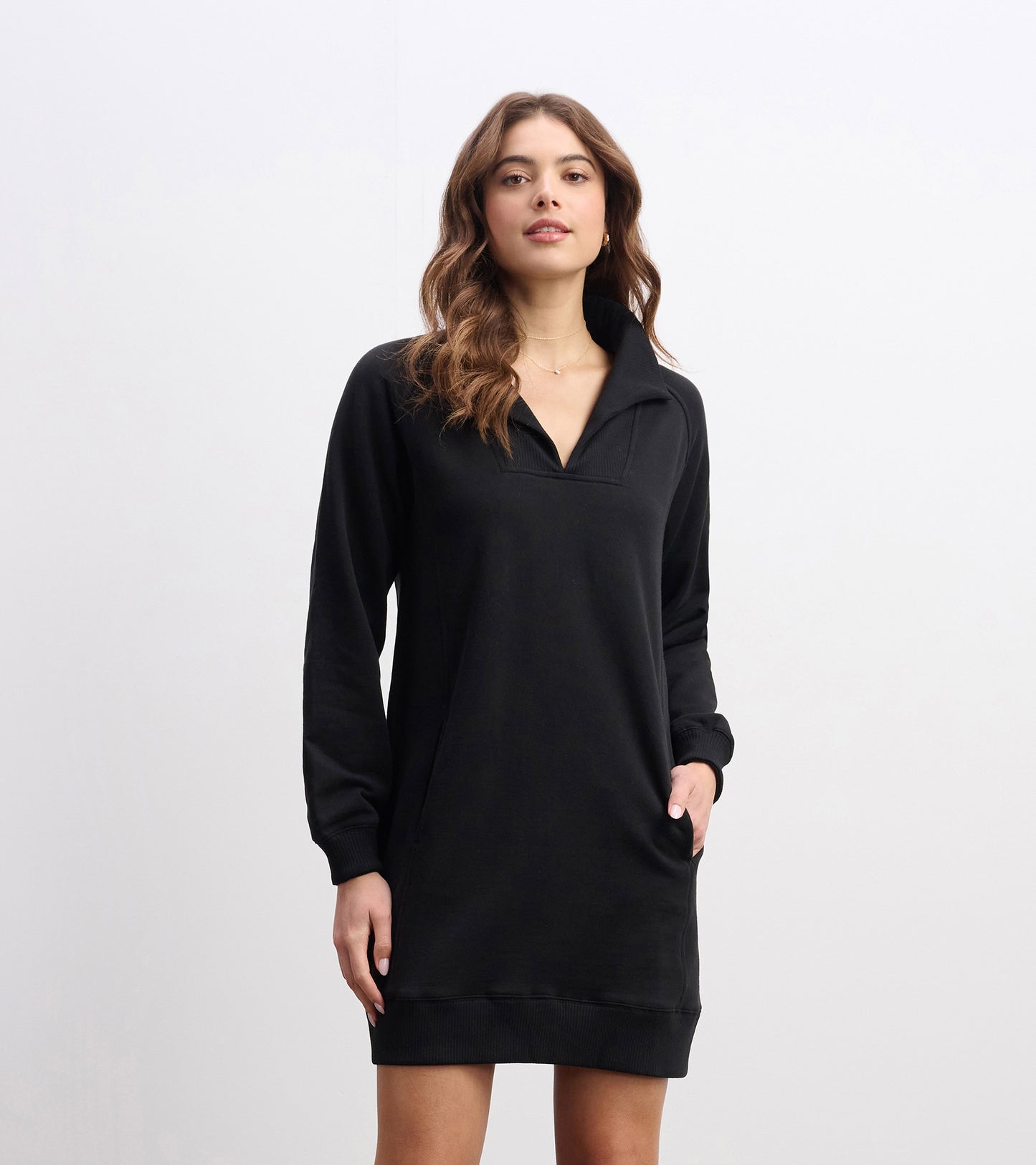 Black notch neck dress with long sleeves and side pockets, designed for casual wear.