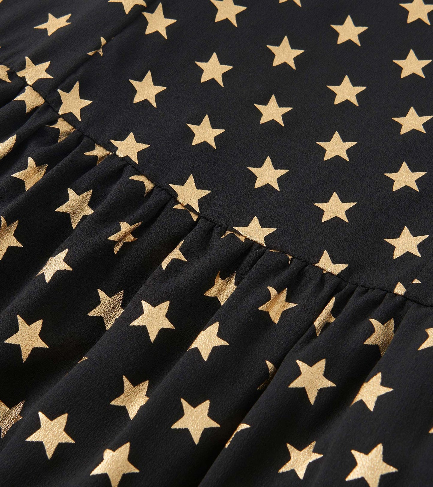 Black dress featuring a gold star pattern with a gathered skirt design.