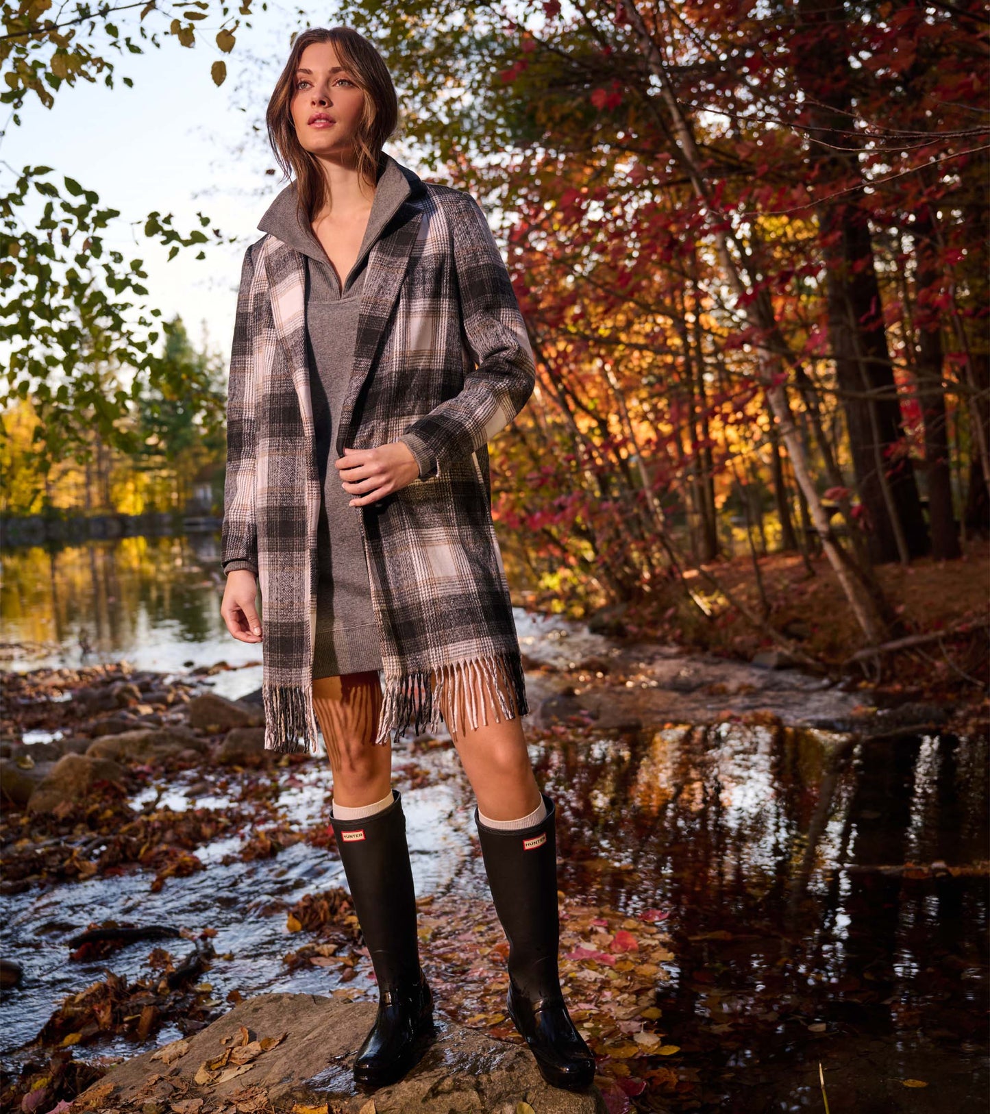 Black, taupe, and white plaid fringe jacket worn open over a gray top, front view