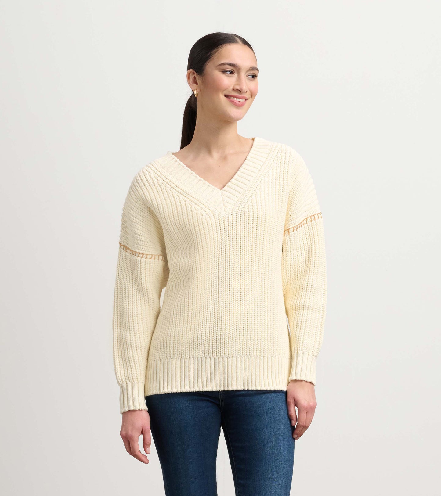 Cream V-neck slouchy sweater with ribbed cuffs and hem, featuring a relaxed fit and textured knit pattern.