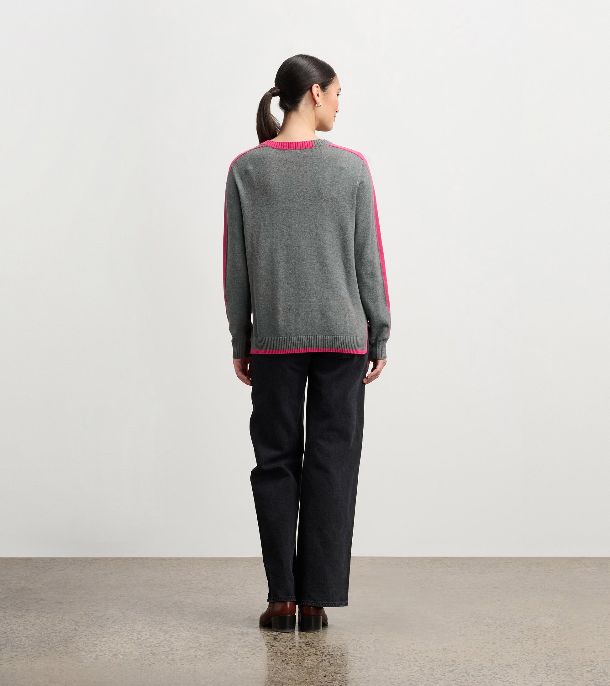 Charcoal sweater with pink contrast trim, featuring a relaxed fit and long sleeves, viewed from the back.