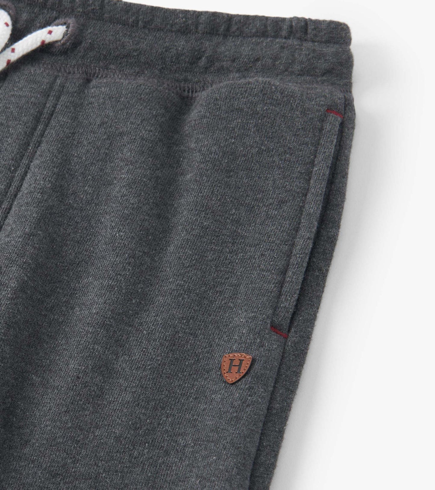 Charcoal melange joggers with a drawstring waist, side pockets, and a small logo patch on the front.