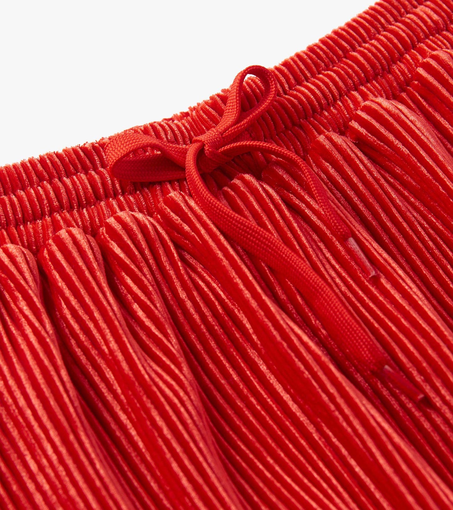 Red pleated velour skirt with an elastic waistband and bow detail at the front.