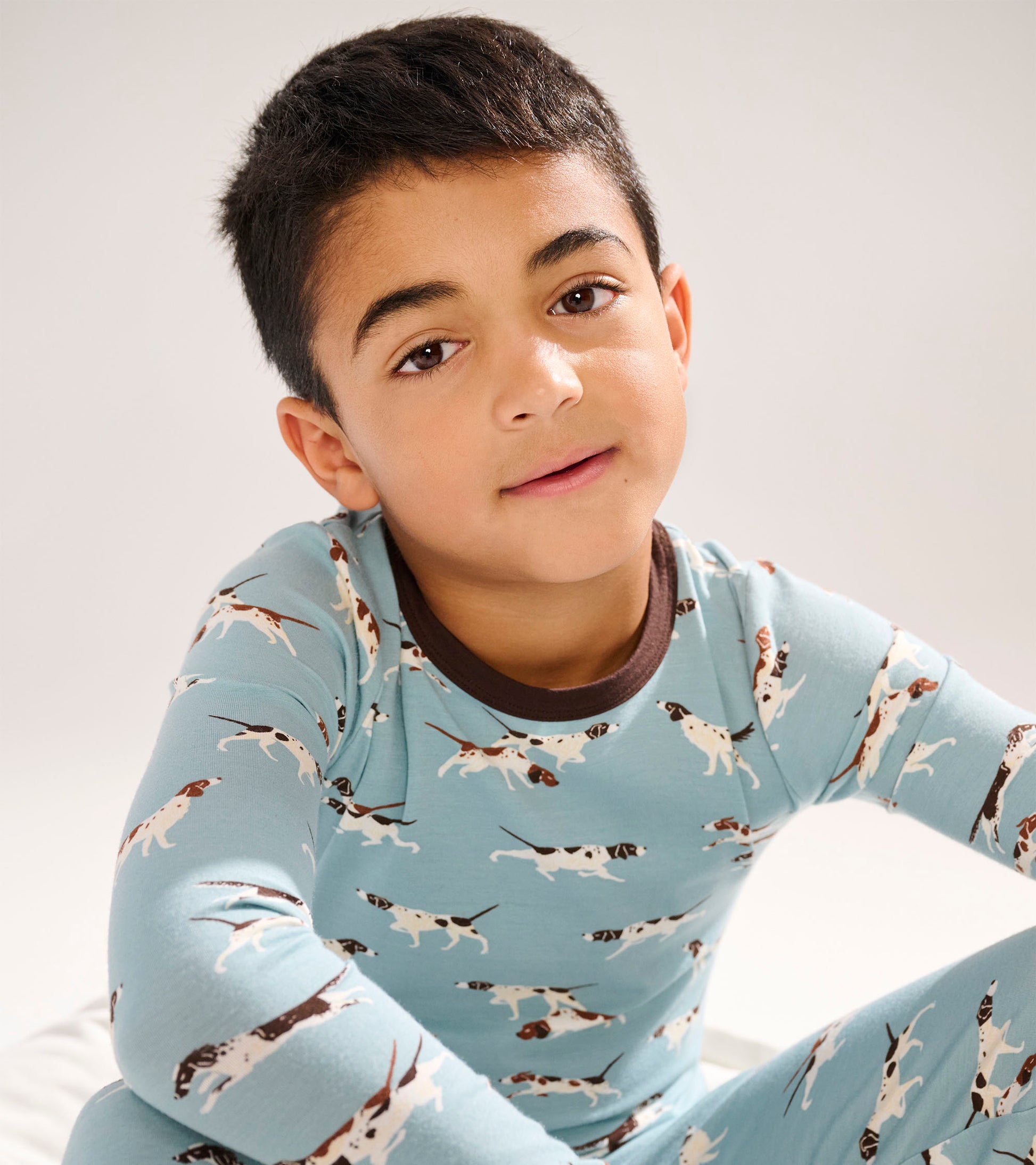 Light blue bamboo pajama set featuring playful hunting dog patterns, with a brown collar and cuffs.