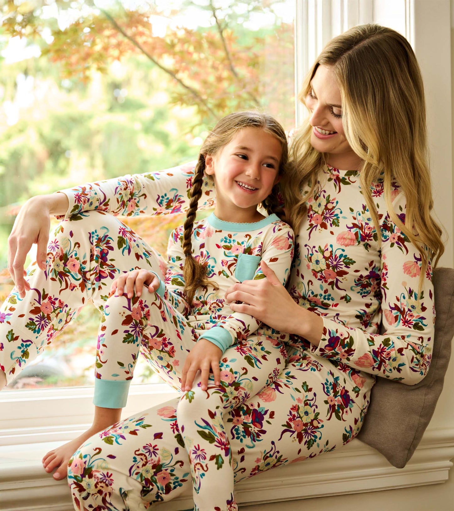 Floral-patterned bamboo pajama set in cream, featuring long sleeves and pants, worn by a mother and daughter.