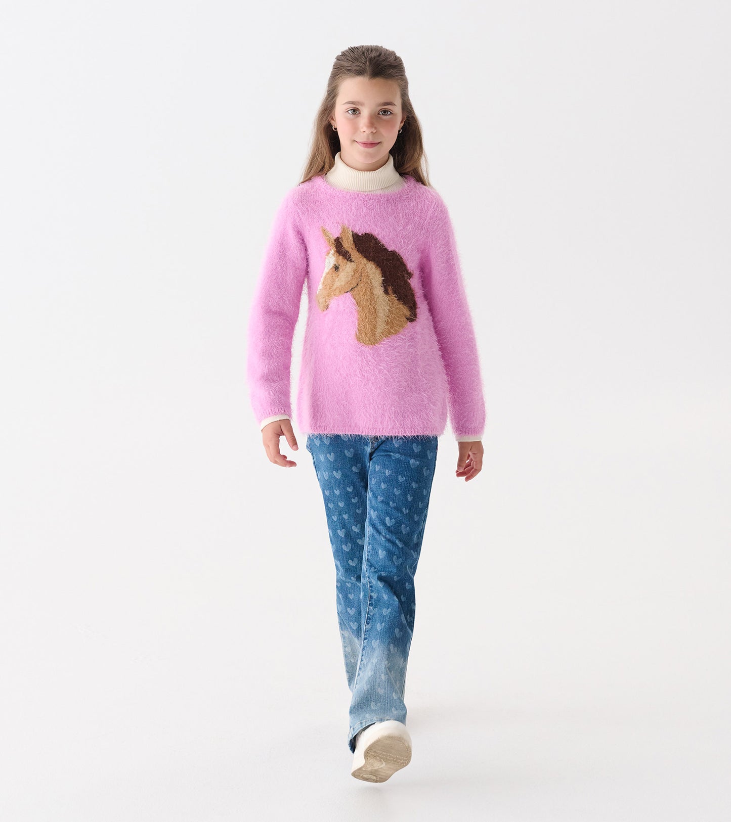 Pink fuzzy sweater featuring a unicorn design, worn with blue jeans, suitable for girls.