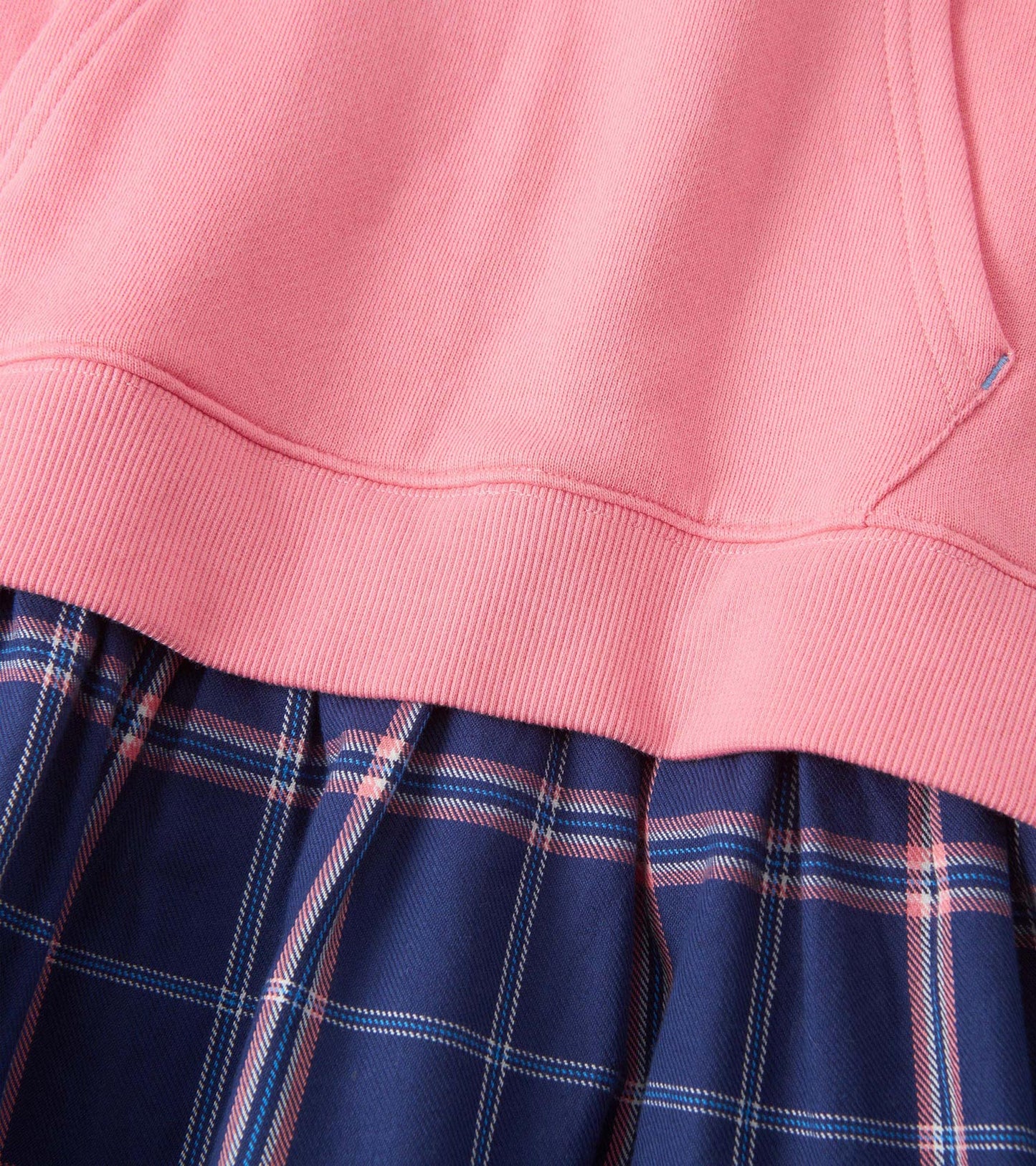 Pink top with ribbed neckline paired with a navy plaid skirt featuring pink and white accents.