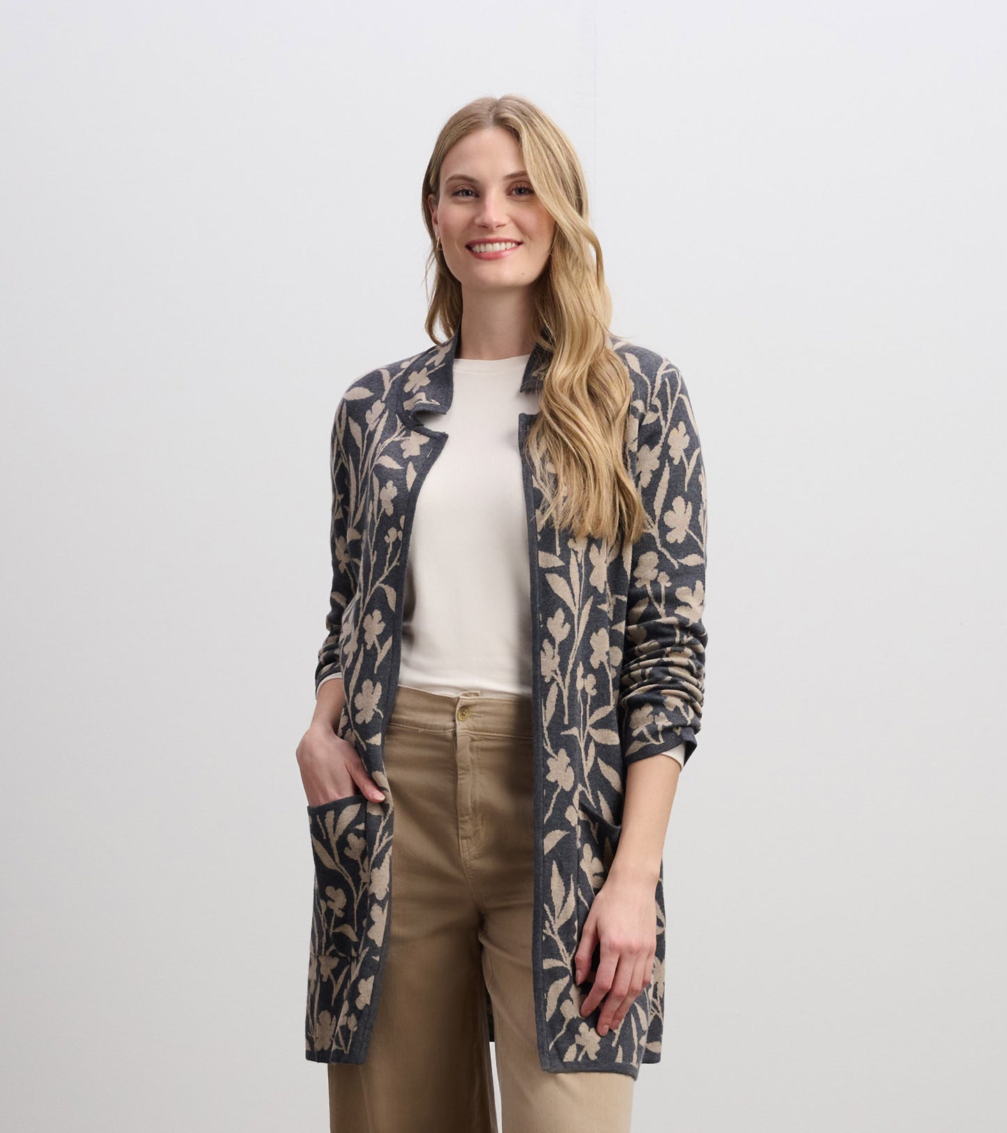 Long-sleeve sweater blazer featuring a floral vine pattern in navy and beige, with an open front and side pockets.