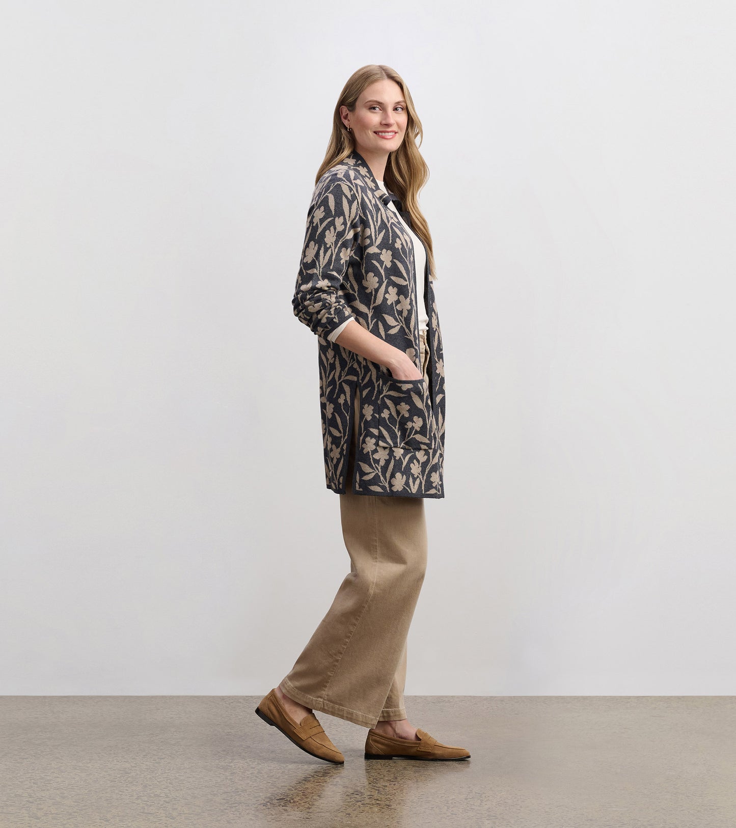 Floral vine patterned sweater blazer in navy and beige, featuring pockets, styled with beige pants and loafers.