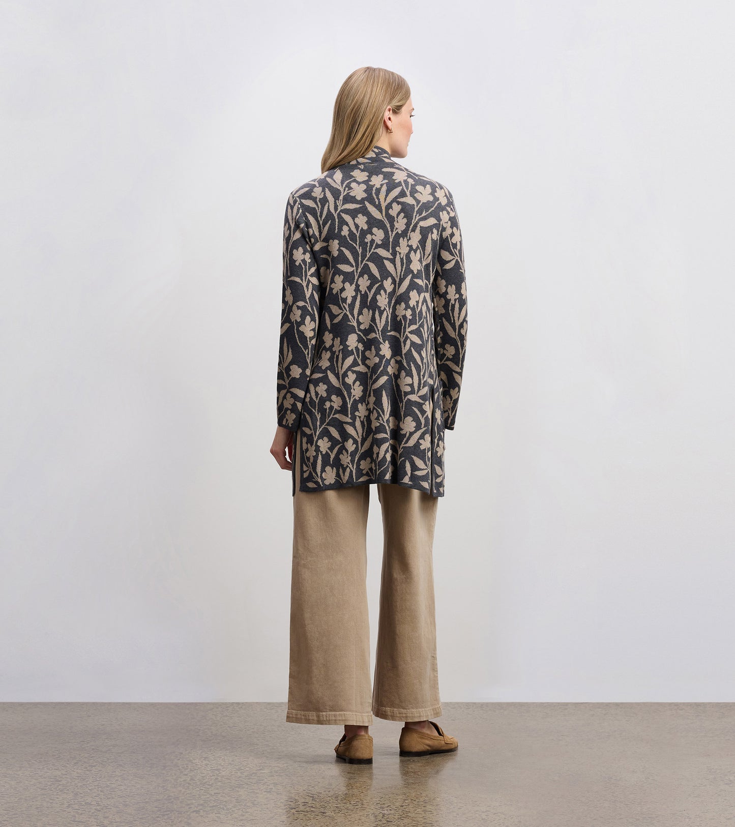 Long-sleeve sweater blazer with floral vine pattern in navy and beige, styled with wide-leg pants.