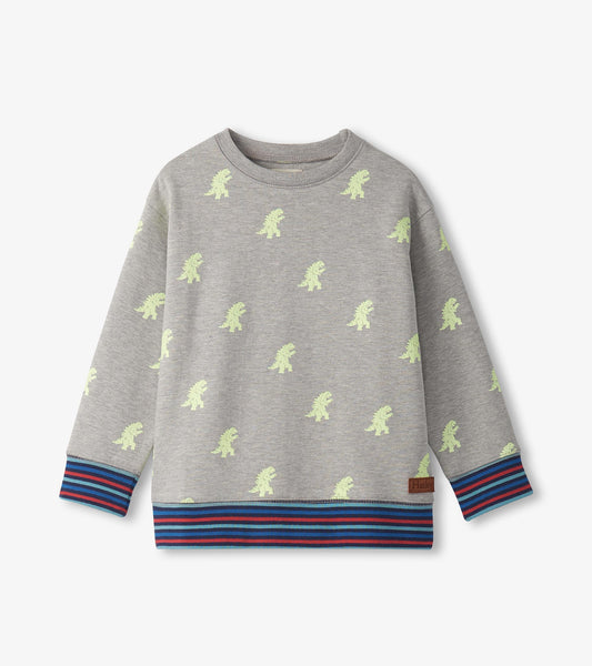 Gray pullover sweatshirt featuring small green monster prints and a striped blue and red hem.