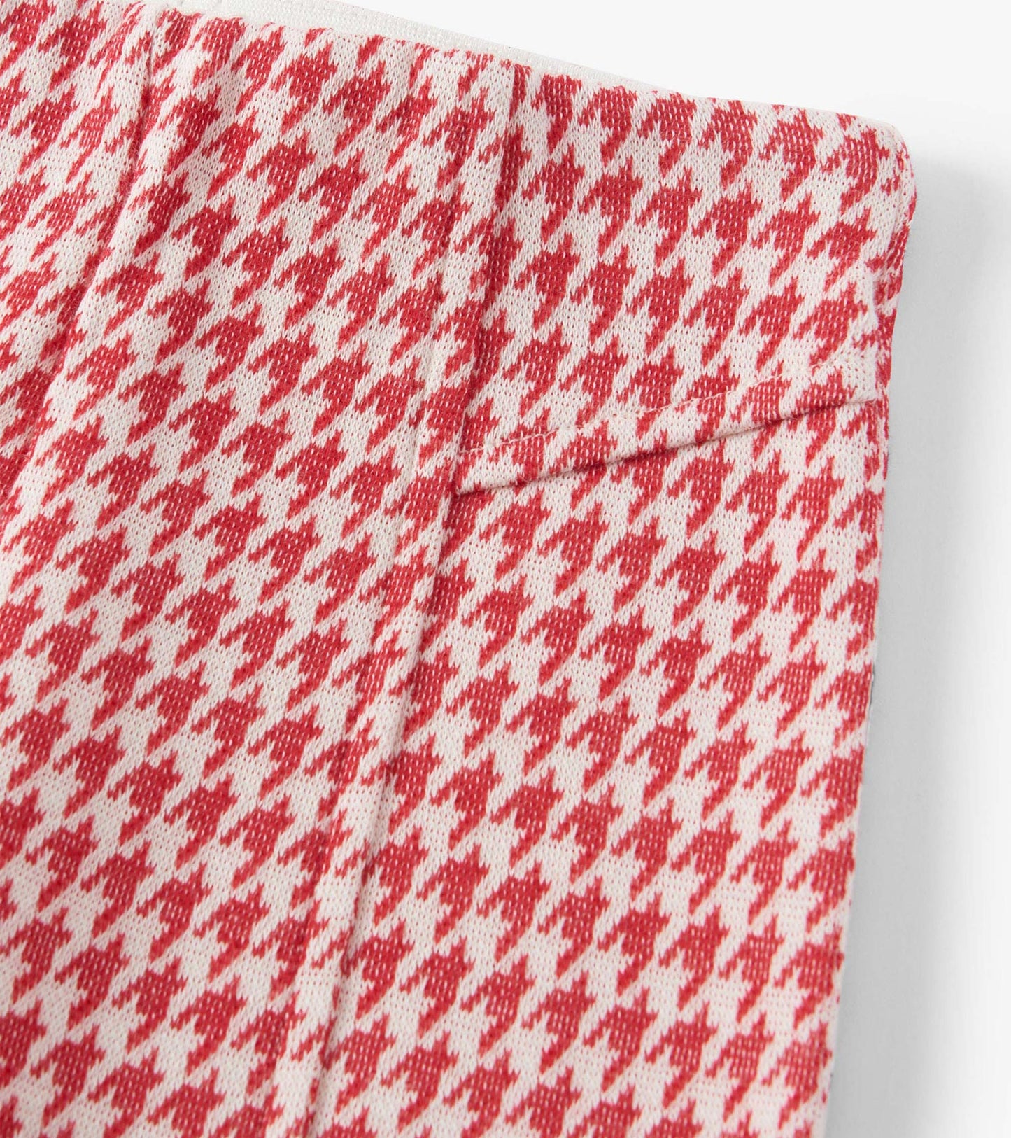 Red and white houndstooth patterned bell bottom pants with a smooth waistband.