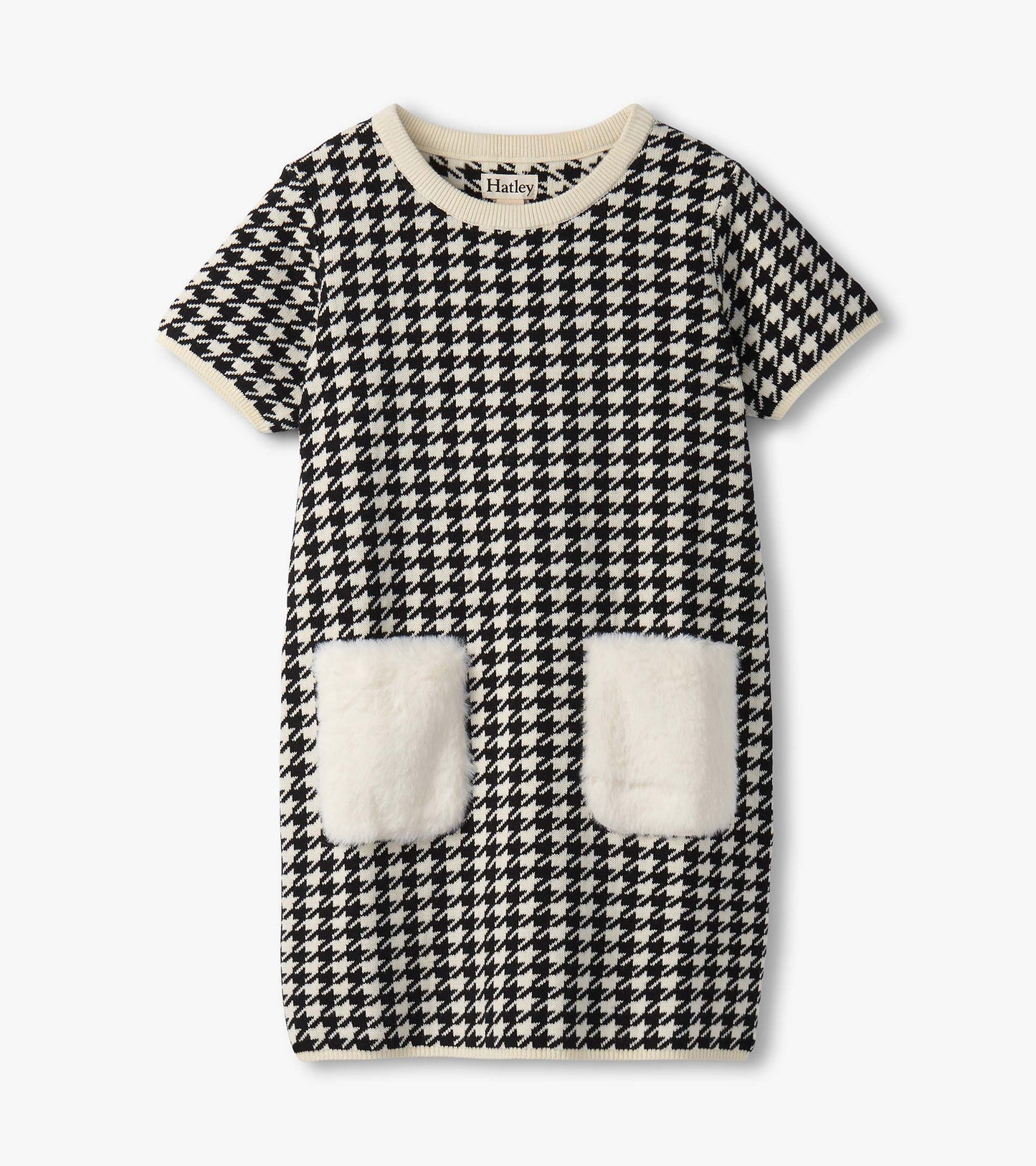 Black and white houndstooth sweater dress featuring faux fur pockets and a ribbed neckline. Short sleeves, casual fit.
