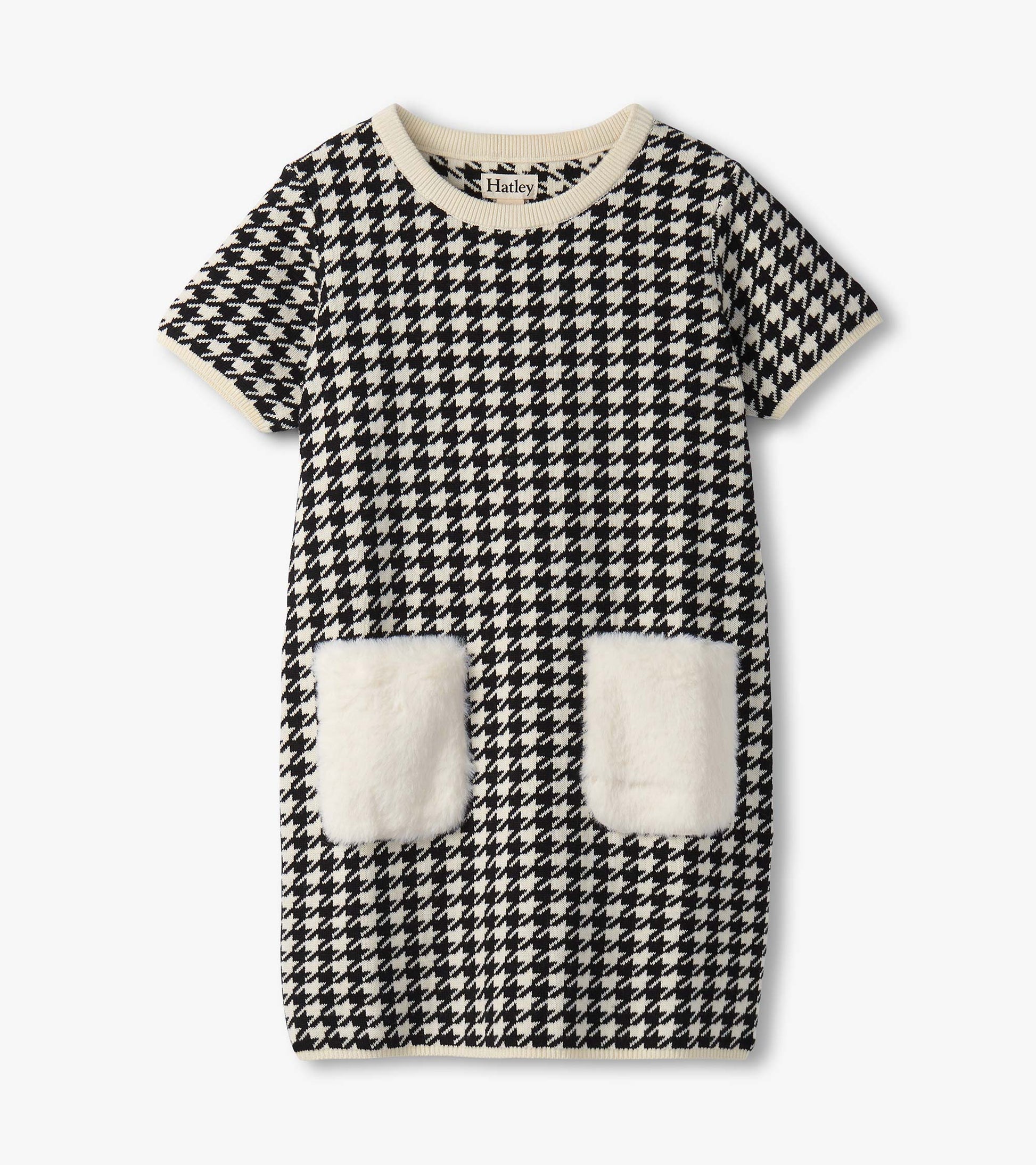 Black and white houndstooth sweater dress featuring faux fur pockets and a ribbed neckline. Short sleeves, casual fit.