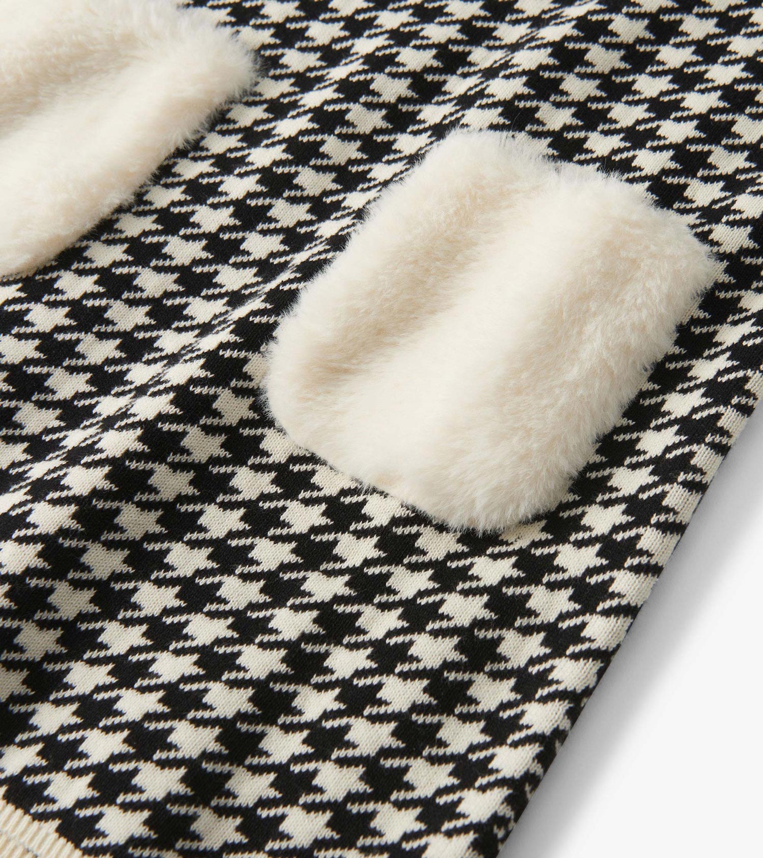 Houndstooth sweater dress featuring faux fur pockets in black and cream, perfect for stylish layering.