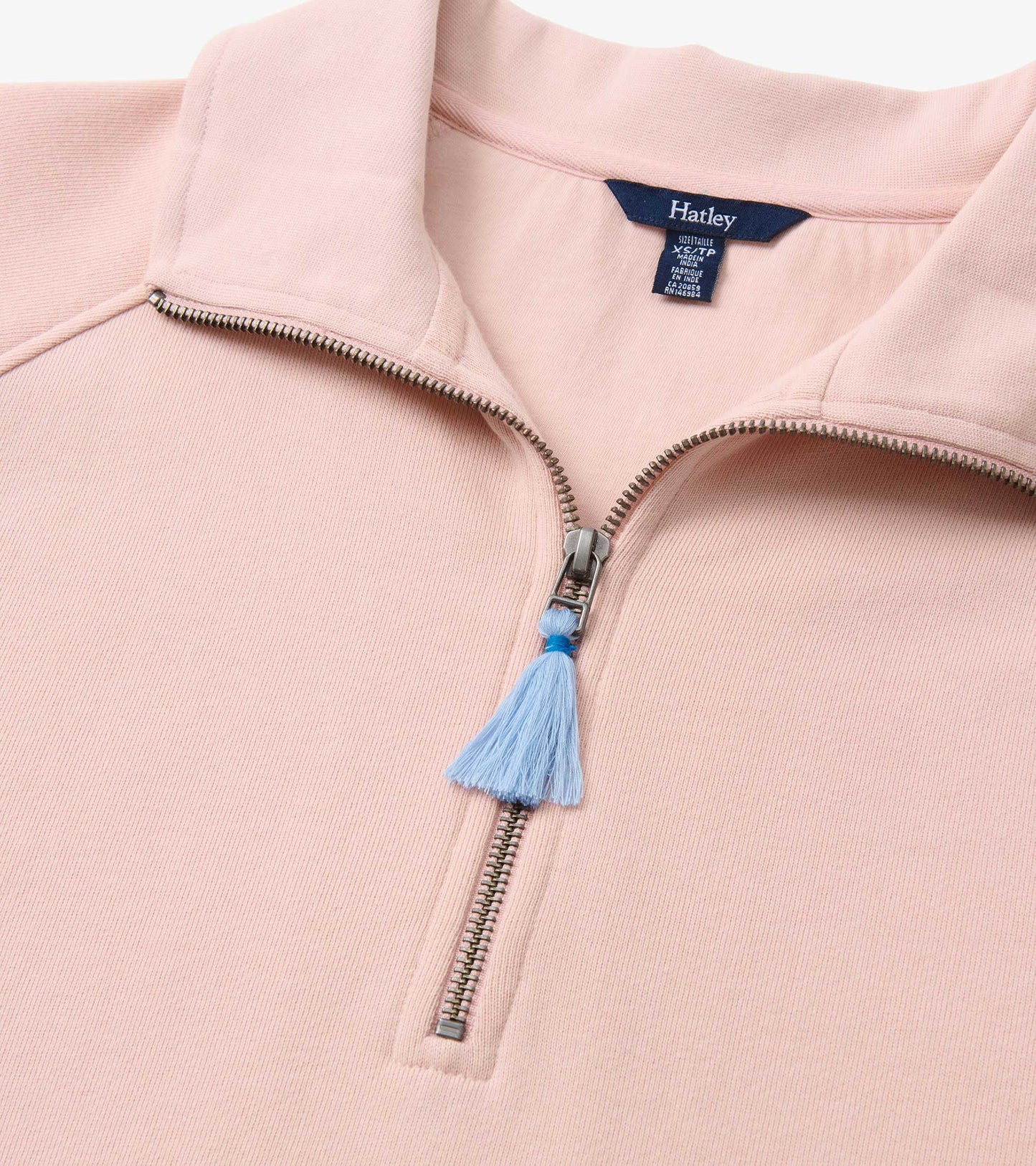 Light pink mock neck pullover sweater with half-zip front and blue tassel pull tab, close-up detail