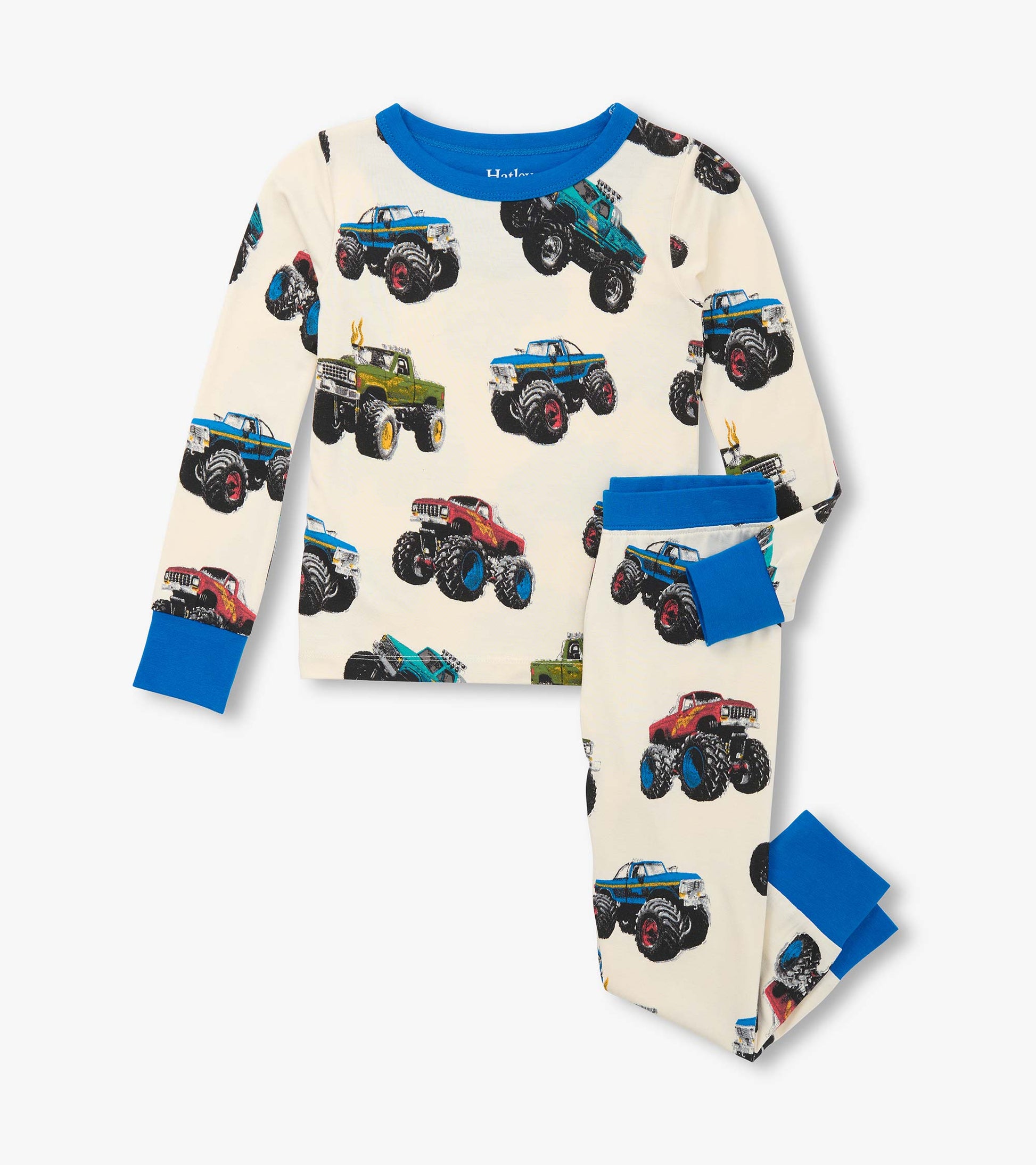 Boys' pajama set featuring colorful monster truck prints on a cream background with blue accents. Long sleeves and pants.