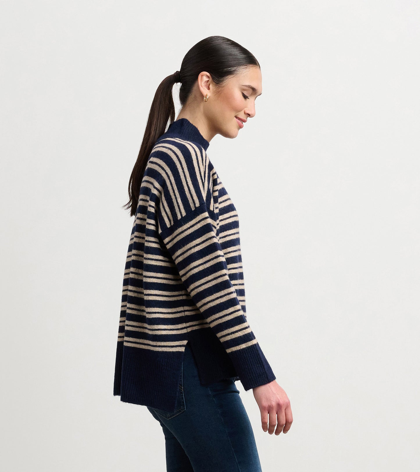 Navy and camel striped mock neck sweater with side slits, worn by a model, showcasing a relaxed fit.