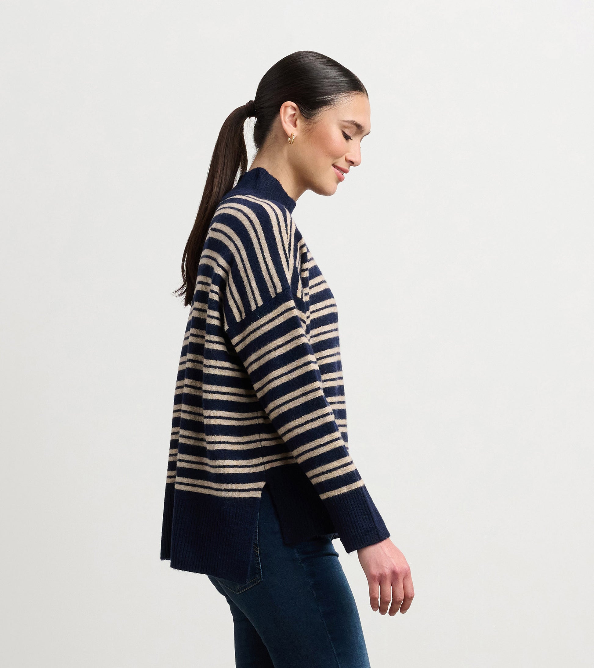 Navy and camel striped mock neck sweater with side slits, worn by a model, showcasing a relaxed fit.