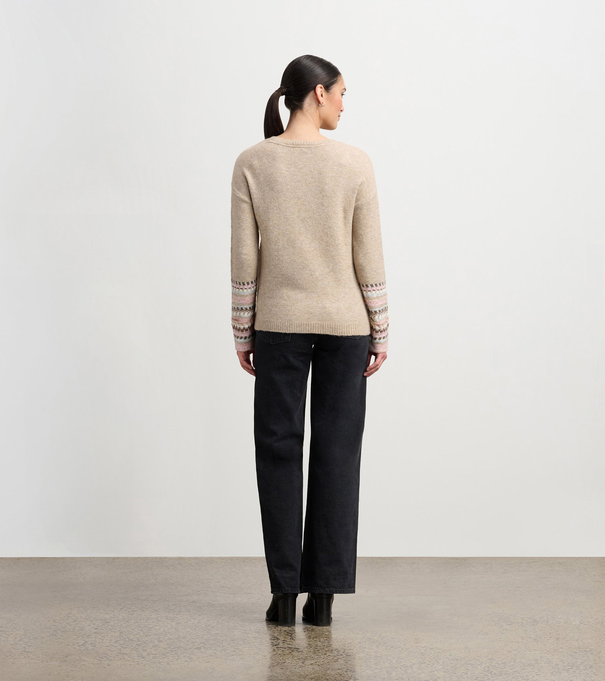 Oatmeal melange sweater with patterned cuffs, featuring a relaxed fit and long sleeves, viewed from the back.