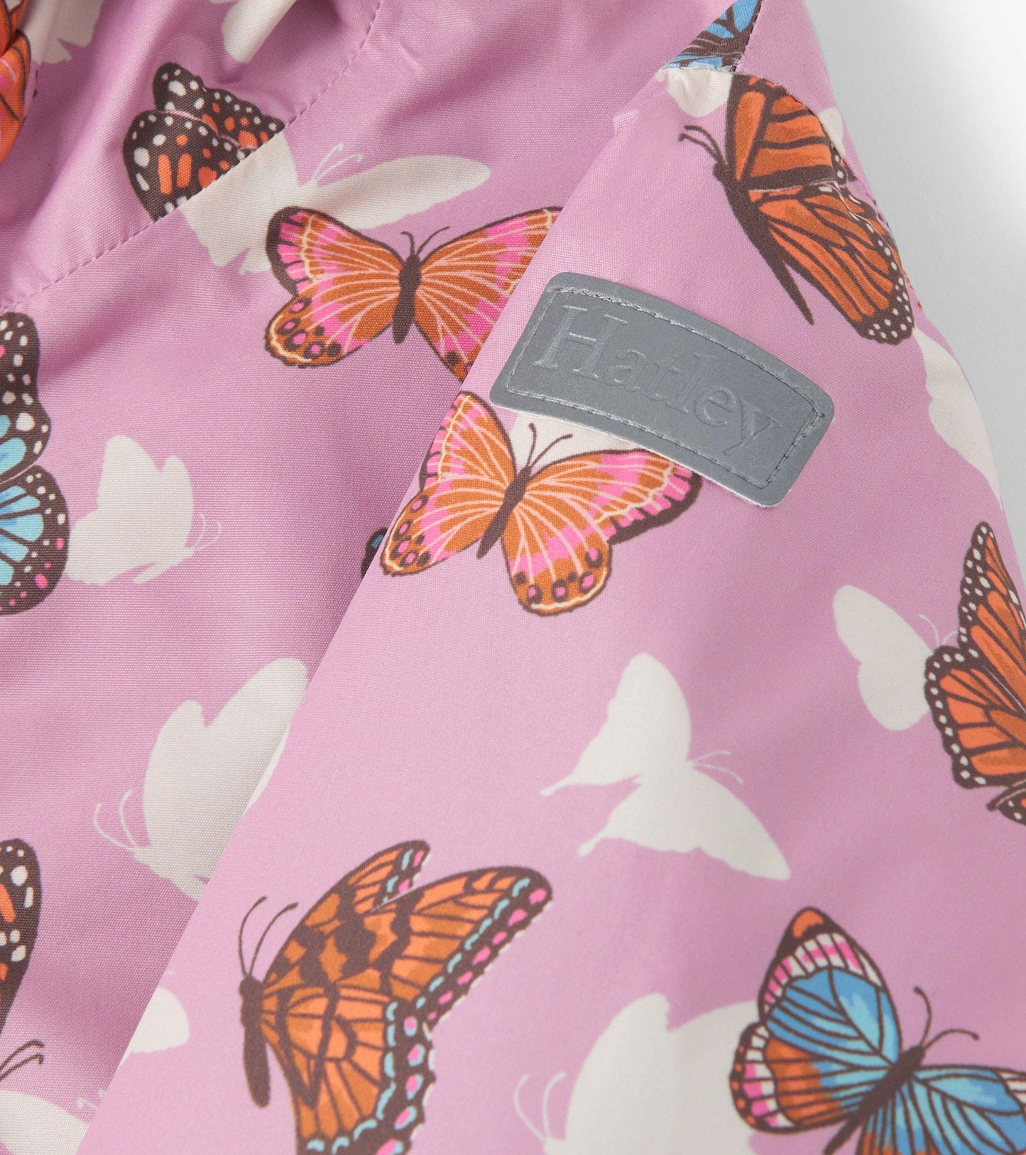 Lightweight zip-up rain jacket in pink with colorful butterfly patterns, perfect for girls.