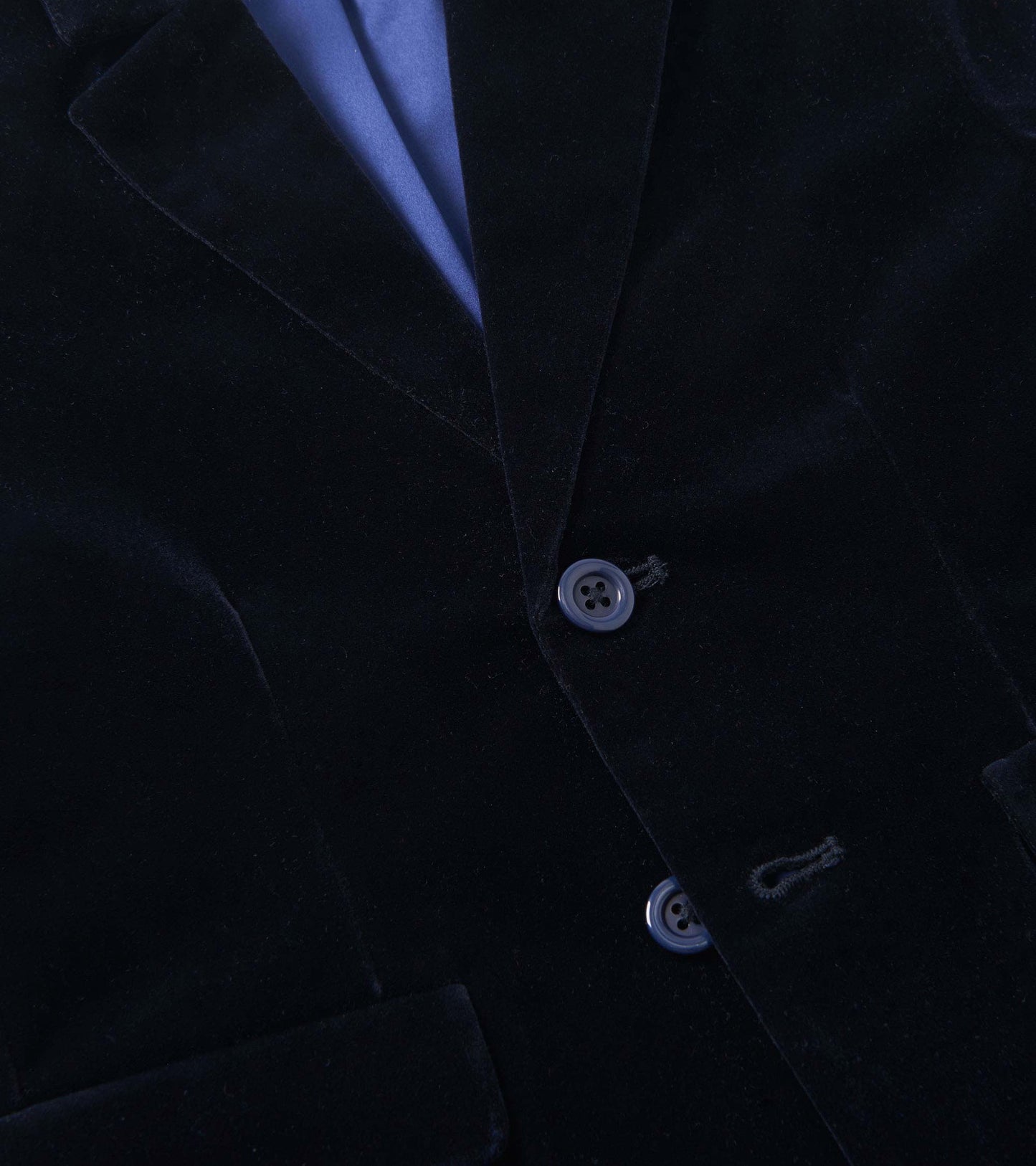 Close-up of a navy velveteen blazer front with lapels and two buttons