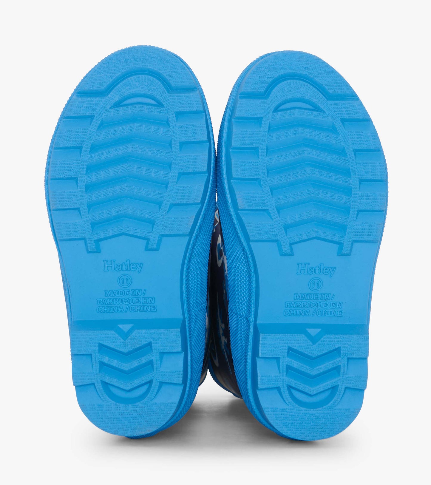 Blue matte rain boots with dinosaur patterns and textured blue soles, designed for boys.
