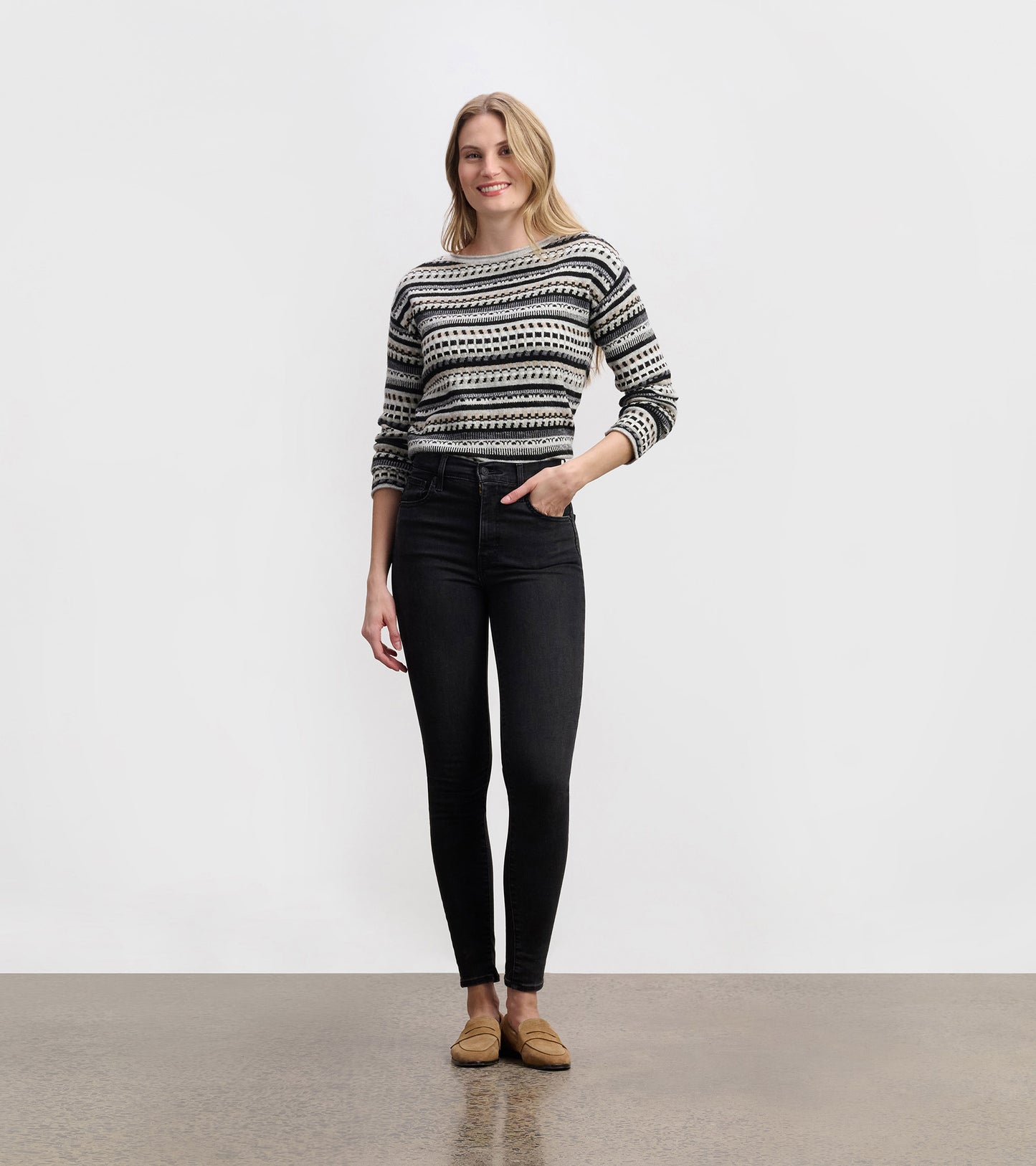 Stone grey patterned knit sweater with black and white geometric stripes, long sleeves, and a crew neck, worn on model.