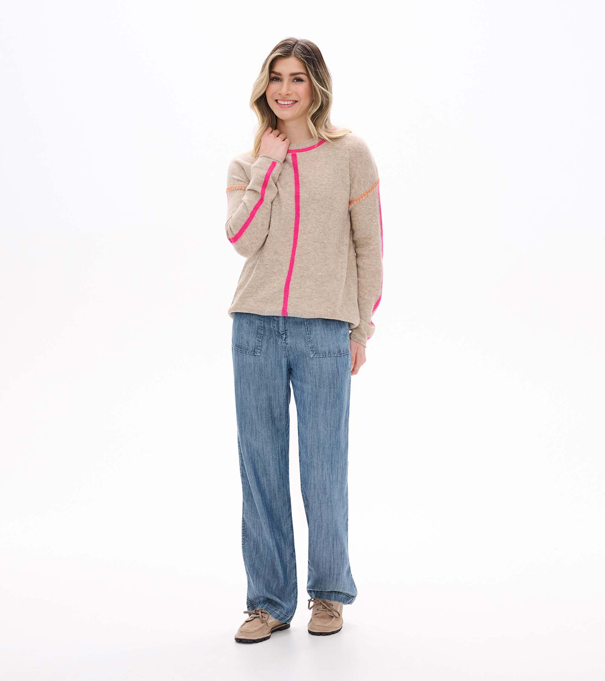 Model wearing oatmeal sweater with neon pink trim and center stripe, full front view
