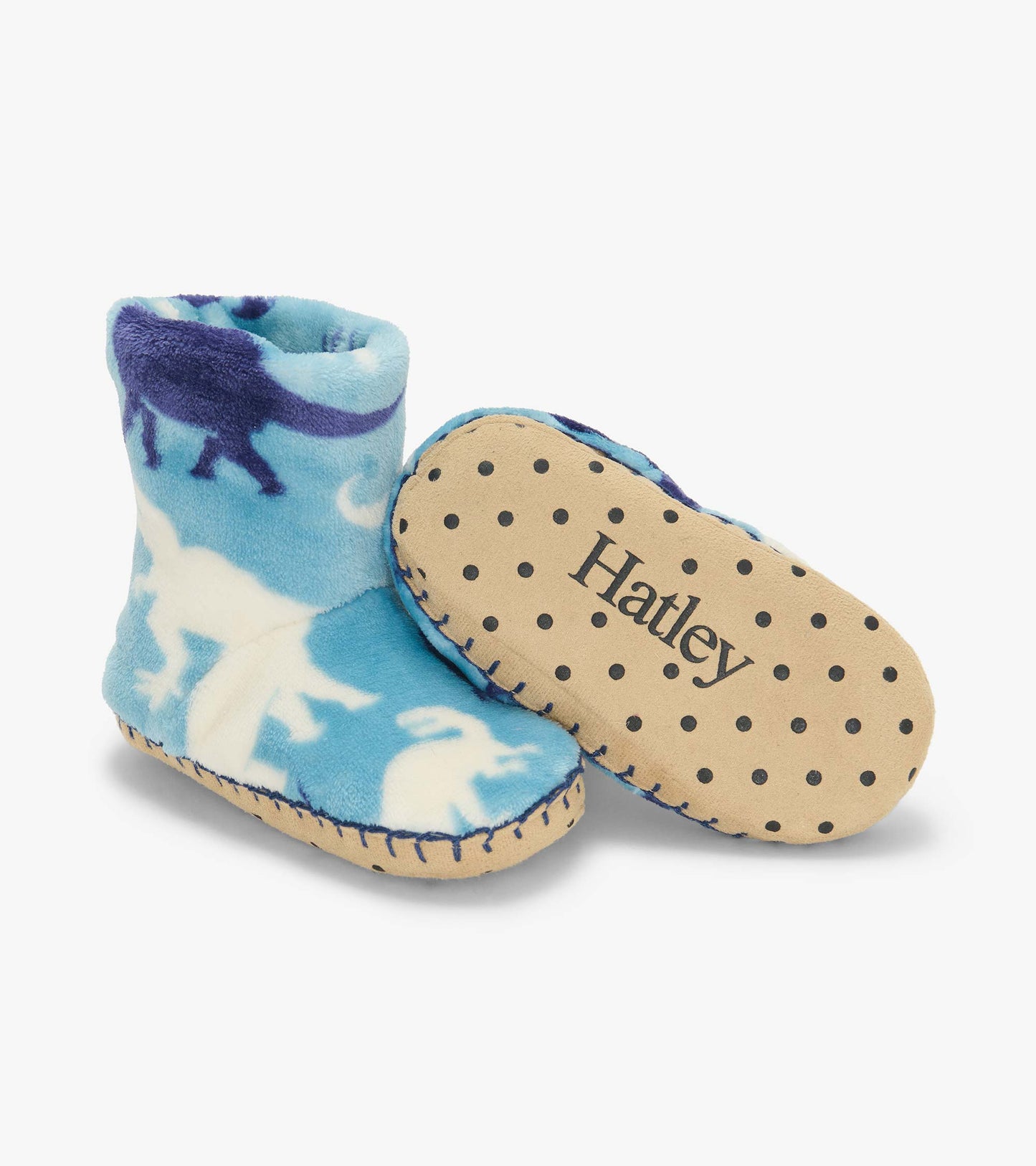 Blue dinosaur print slipper boots with one sole shown, featuring black grip dots and Hatley logo