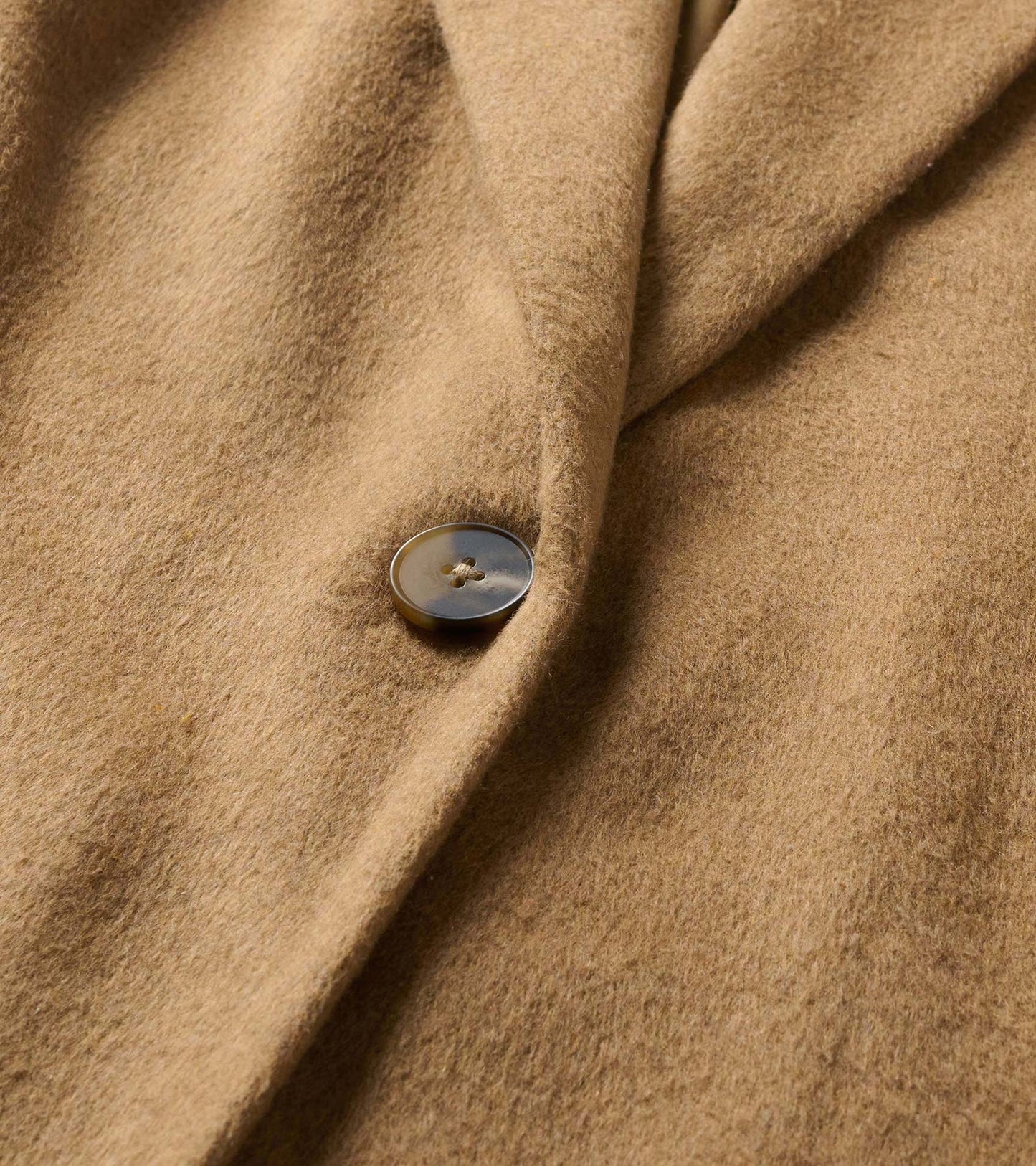 Close-up of the burro brown jacket showing the button and soft brushed surface
