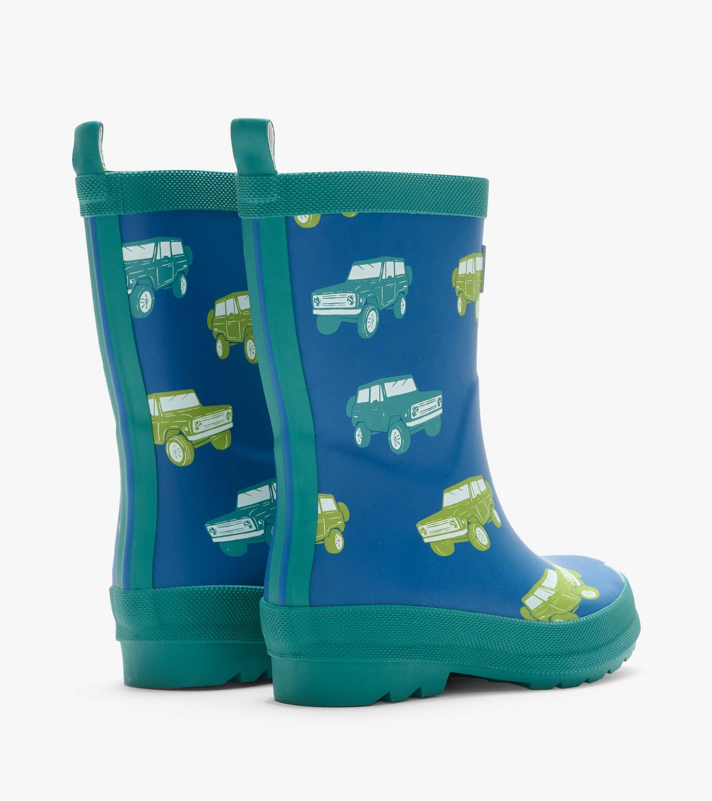Rear angled view of blue matte rain boots with green trim, pull tabs, and vintage truck print