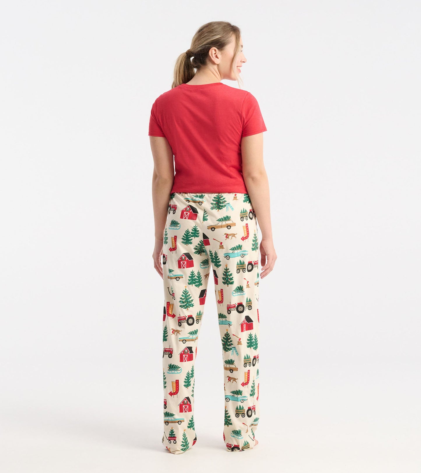 Cream cotton pajama pants featuring a festive Christmas tree farm pattern with barns, tractors, and trees.
