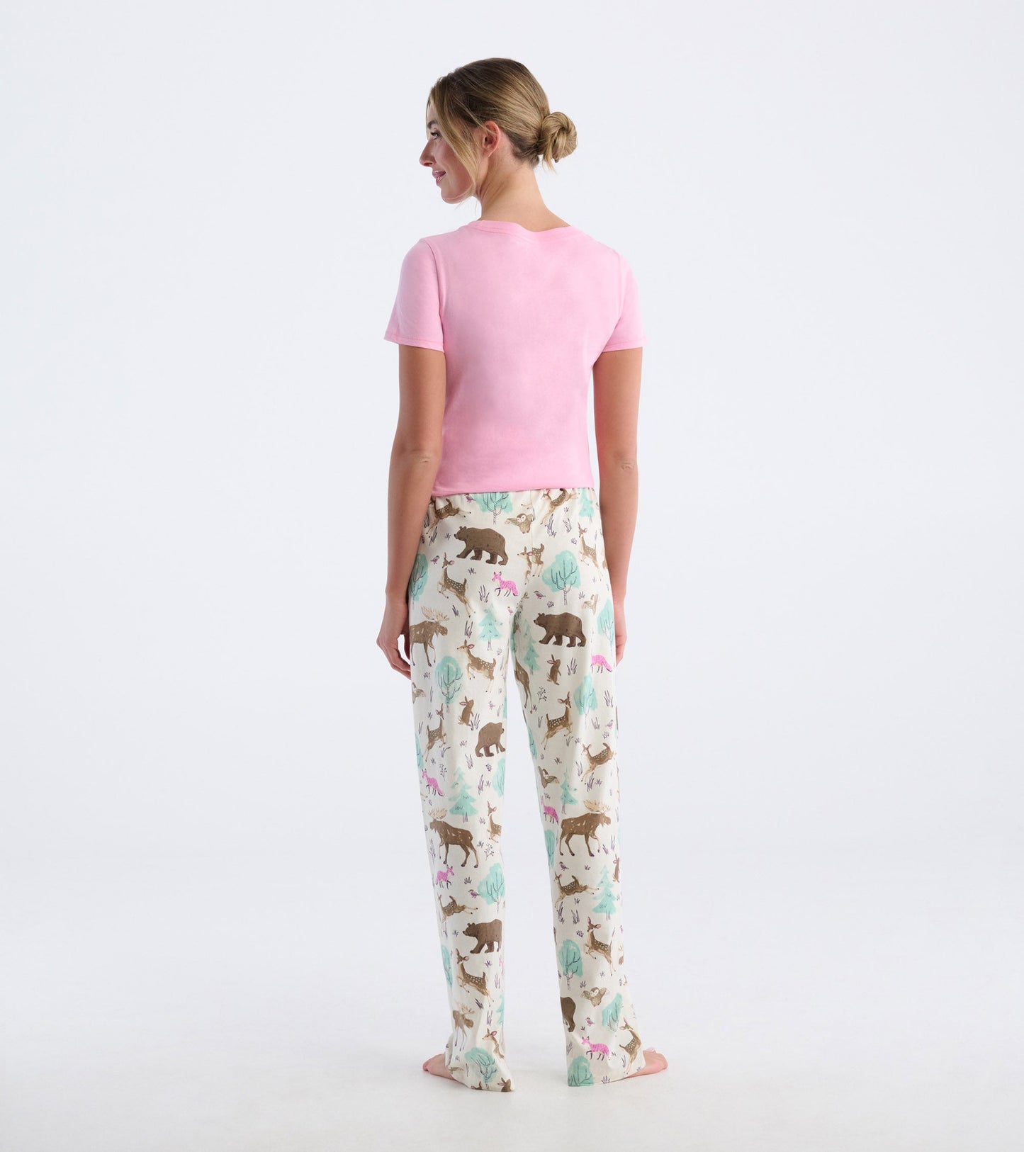 Cotton pajama pants featuring a playful forest animal print in soft colors, styled with a pink short-sleeve top.