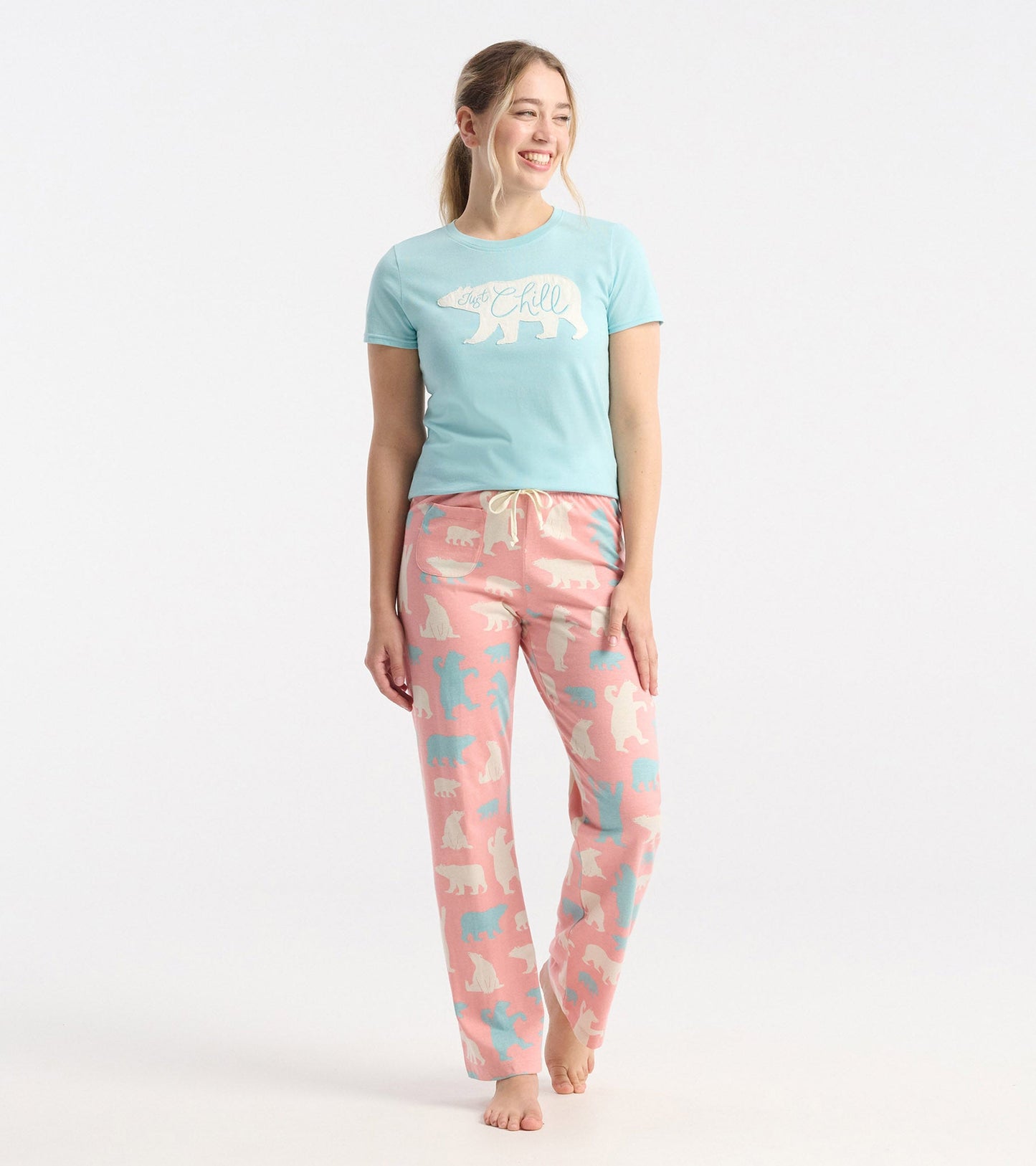 Women's pink cotton pajama pants featuring a polar bear pattern in white and blue, with an elastic waistband and drawstring.