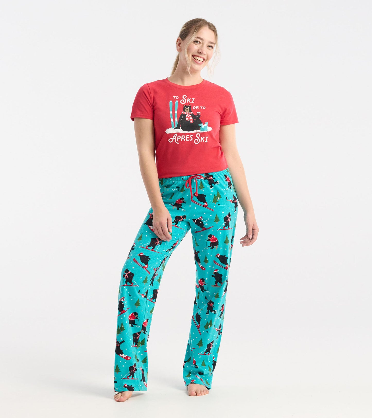 Turquoise cotton pajama pants with a winter sports pattern, featuring skiers and trees, paired with a red t-shirt.
