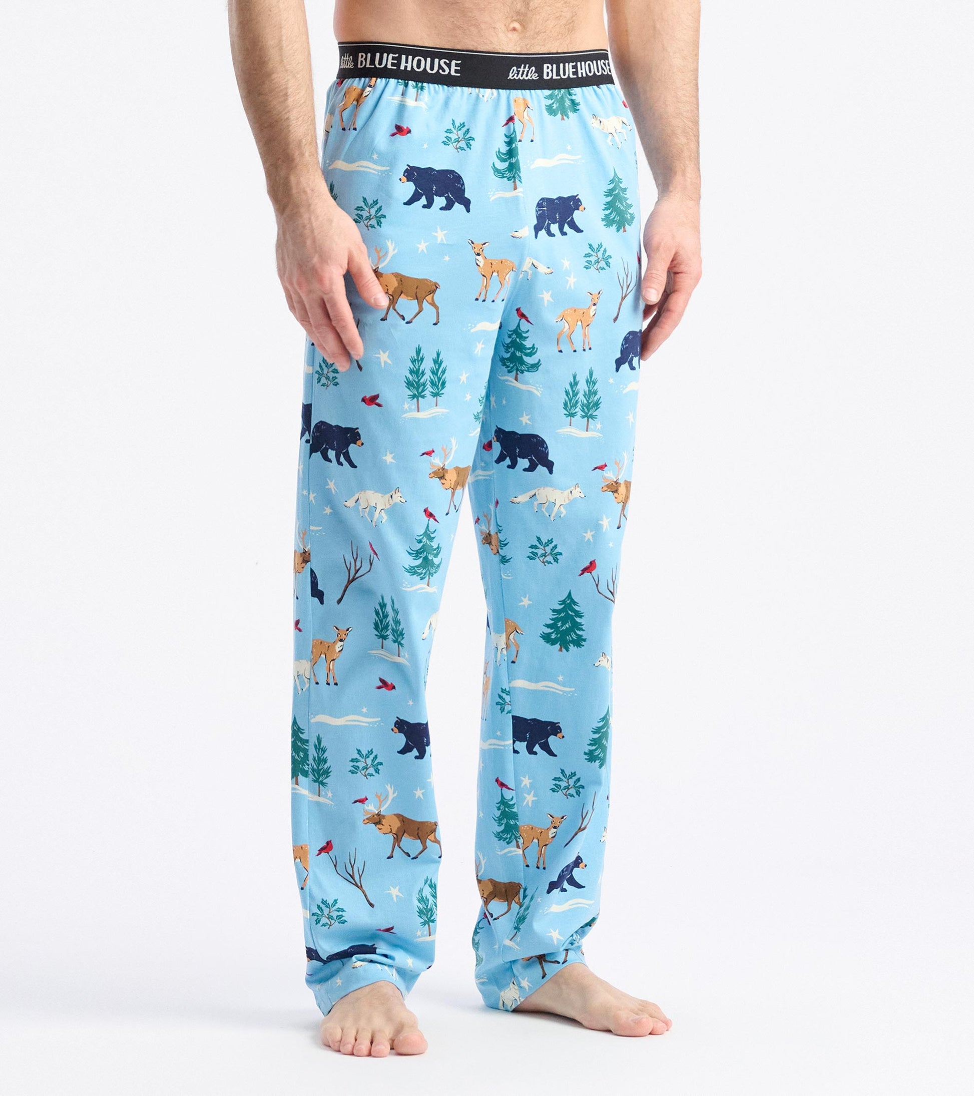 Light blue pajama pants featuring a winter wildlife pattern with bears, deer, and trees, elastic waistband, relaxed fit.