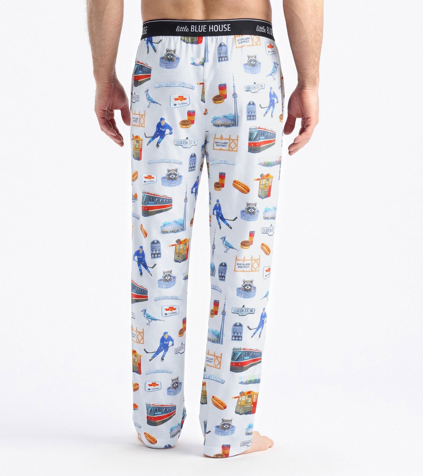 Back view of men's white pajama pants with Toronto-themed print and black Little Blue House waistband