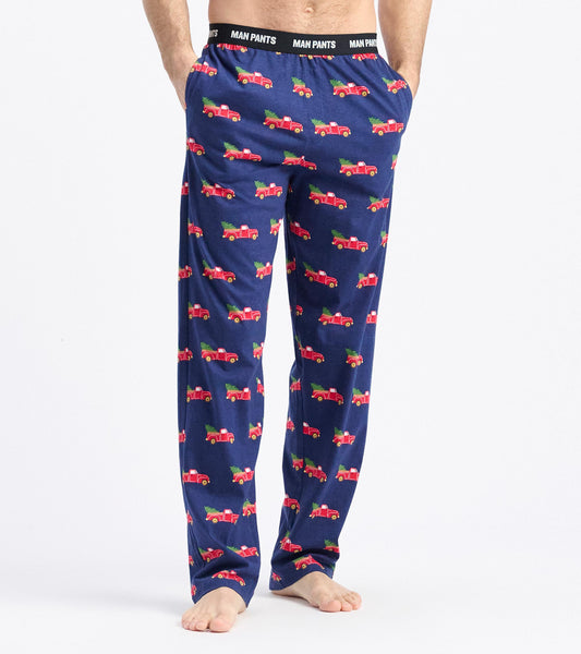 Navy pants featuring a playful pattern of red trucks hauling Christmas trees. Elastic waistband for comfort.