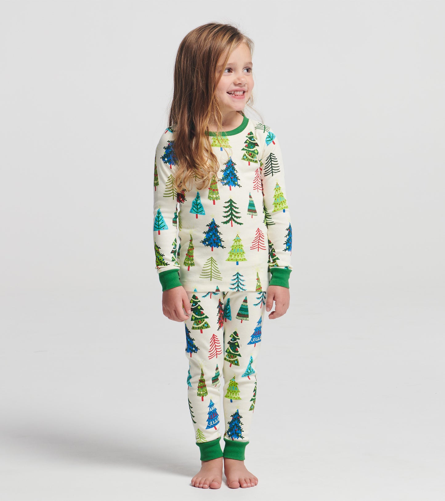Long-sleeve pajama set featuring colorful Christmas trees on a cream background, with green cuffs and waistband.