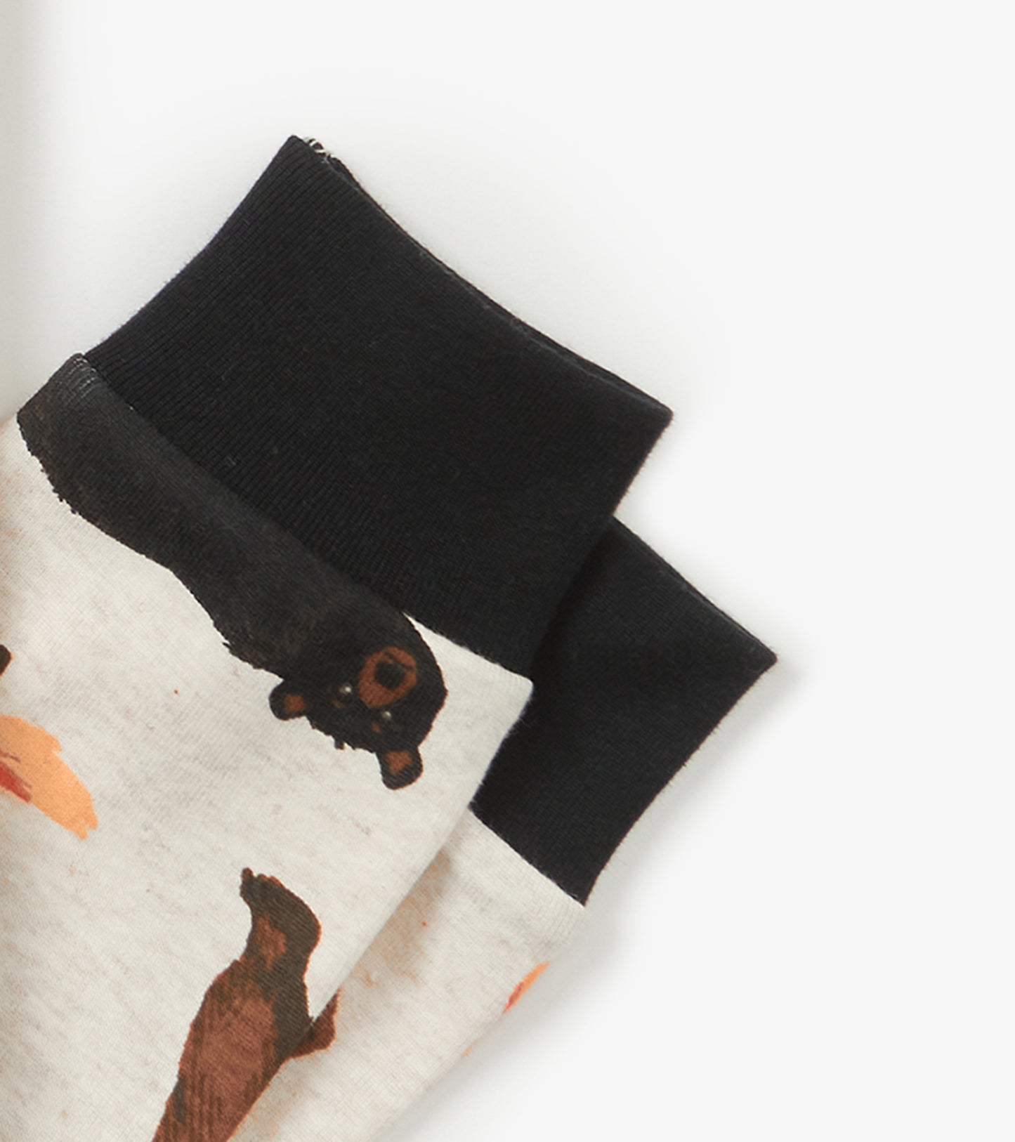 Kids' pajama set featuring a light gray fabric with animal prints and black ribbed cuffs.
