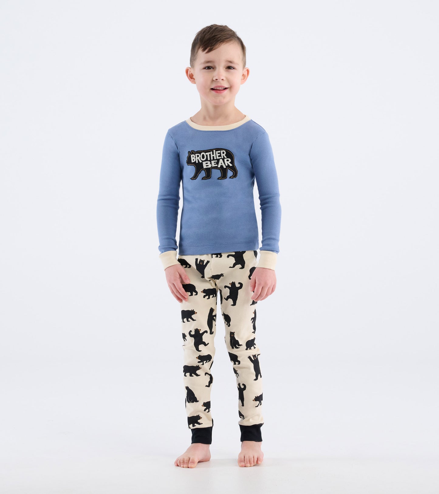 Blue long-sleeve pajama top with "Brother Bear" graphic, paired with cream pants featuring black bear silhouettes.