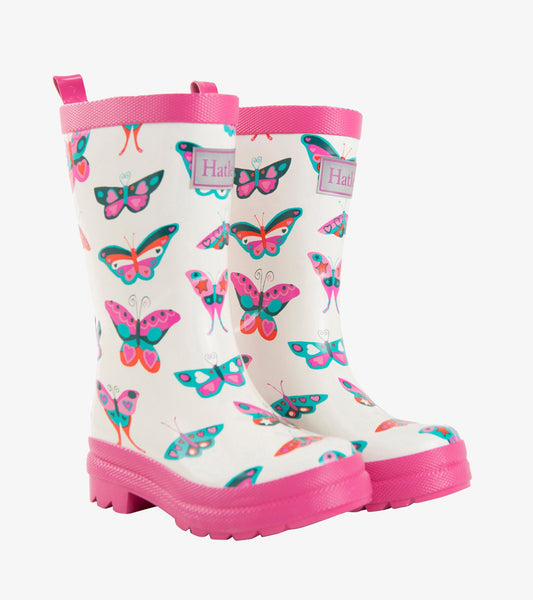 White rain boots with colorful butterfly patterns and pink accents, featuring a textured sole and pull tabs.