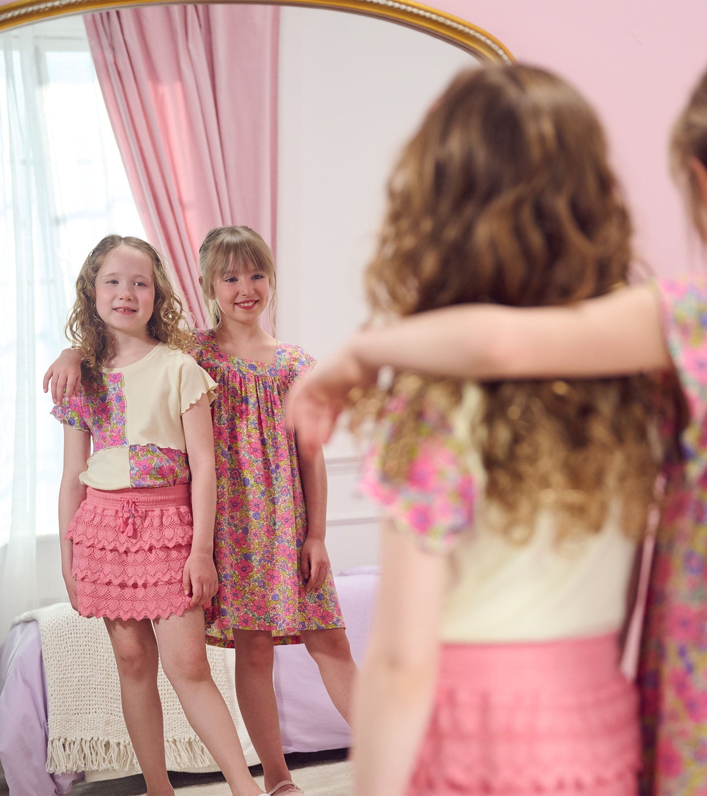 Pink skort with heart pattern, featuring a layered ruffle design, worn by a girl in a bright room with a mirror.