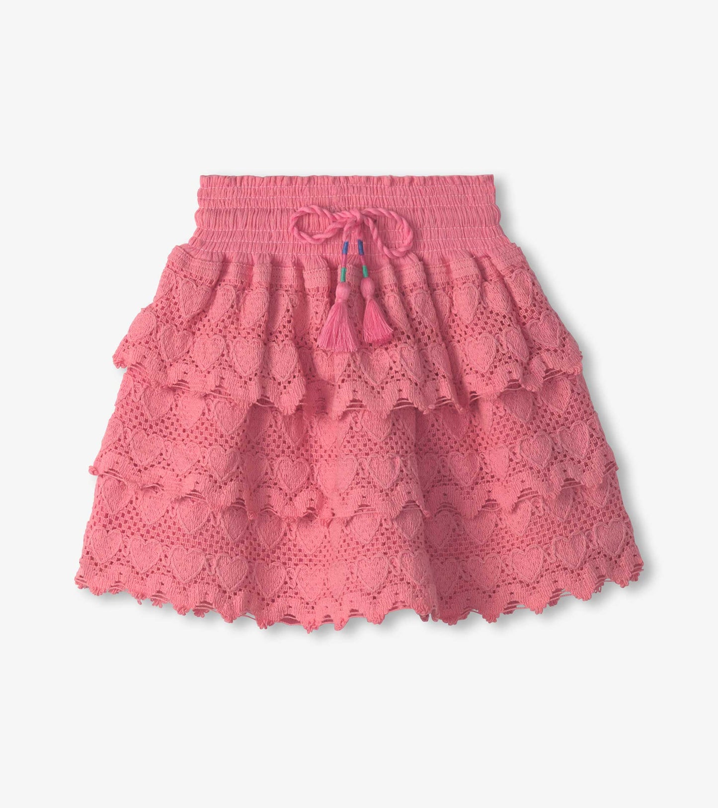 Pink floaty skort featuring layered ruffles and a heart pattern, with a smocked waistband and tassel tie detail.