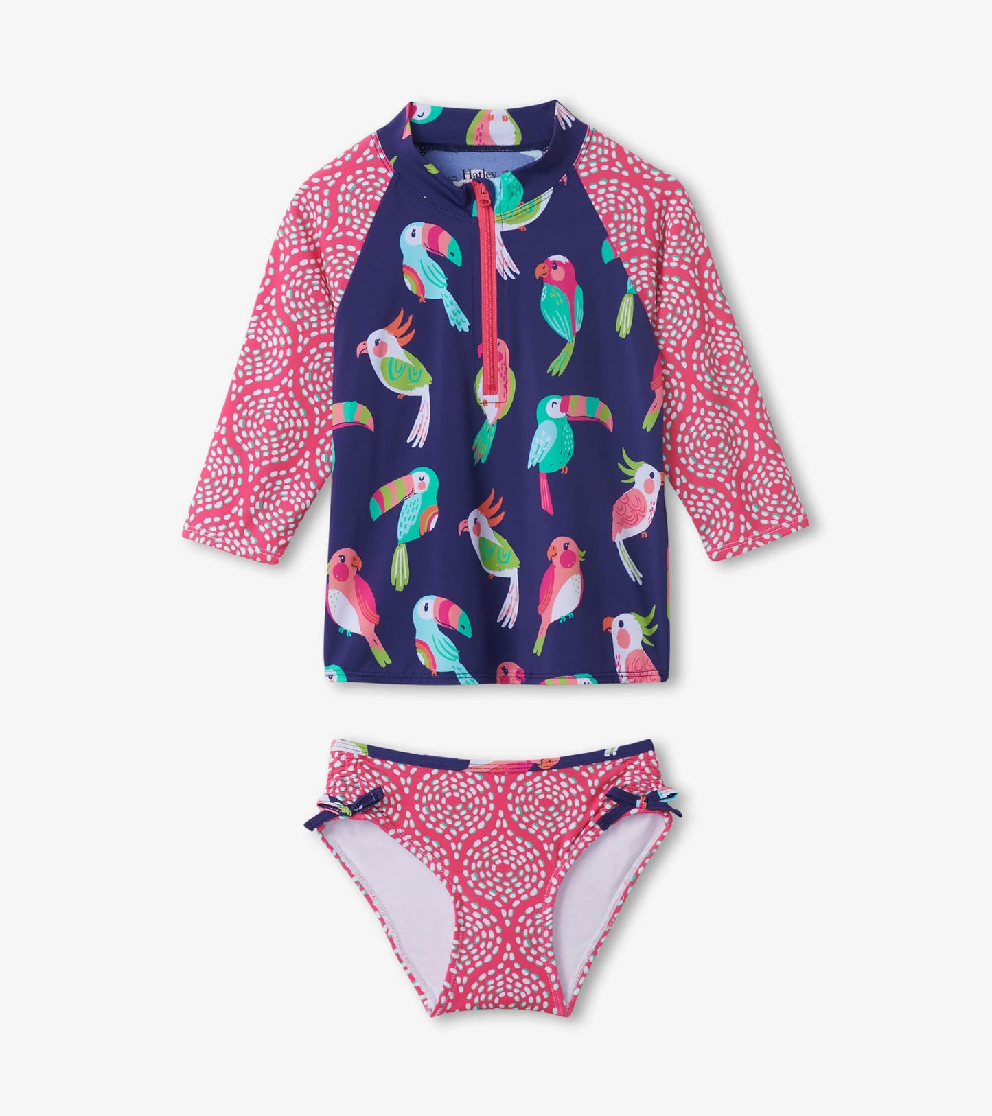 Navy rashguard set featuring colorful tropical birds and pink patterned accents, includes long-sleeve top and matching bikin…