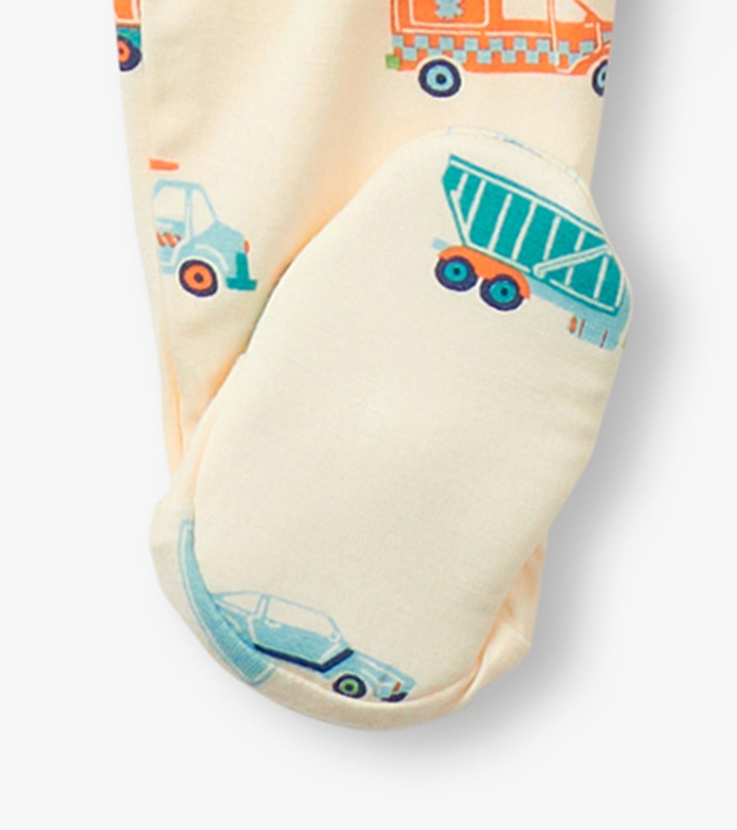Cream footed sleeper featuring colorful car and truck prints, designed for baby boys, with enclosed feet for warmth.