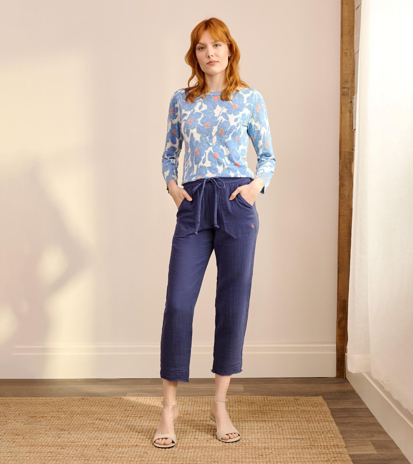 Full-length front view of blue poppy print knit Breton top styled with cropped blue pants