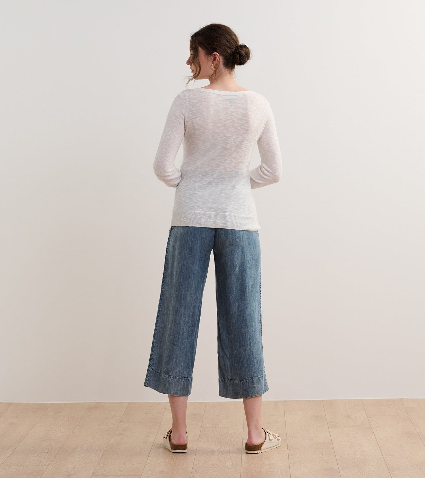 White 3/4 sleeve knit top with a relaxed fit, paired with wide-leg denim pants, viewed from the back.