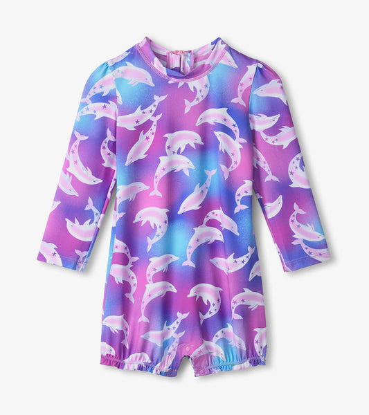Long-sleeve rashguard swimsuit featuring a colorful dolphin print on a gradient purple and blue background.